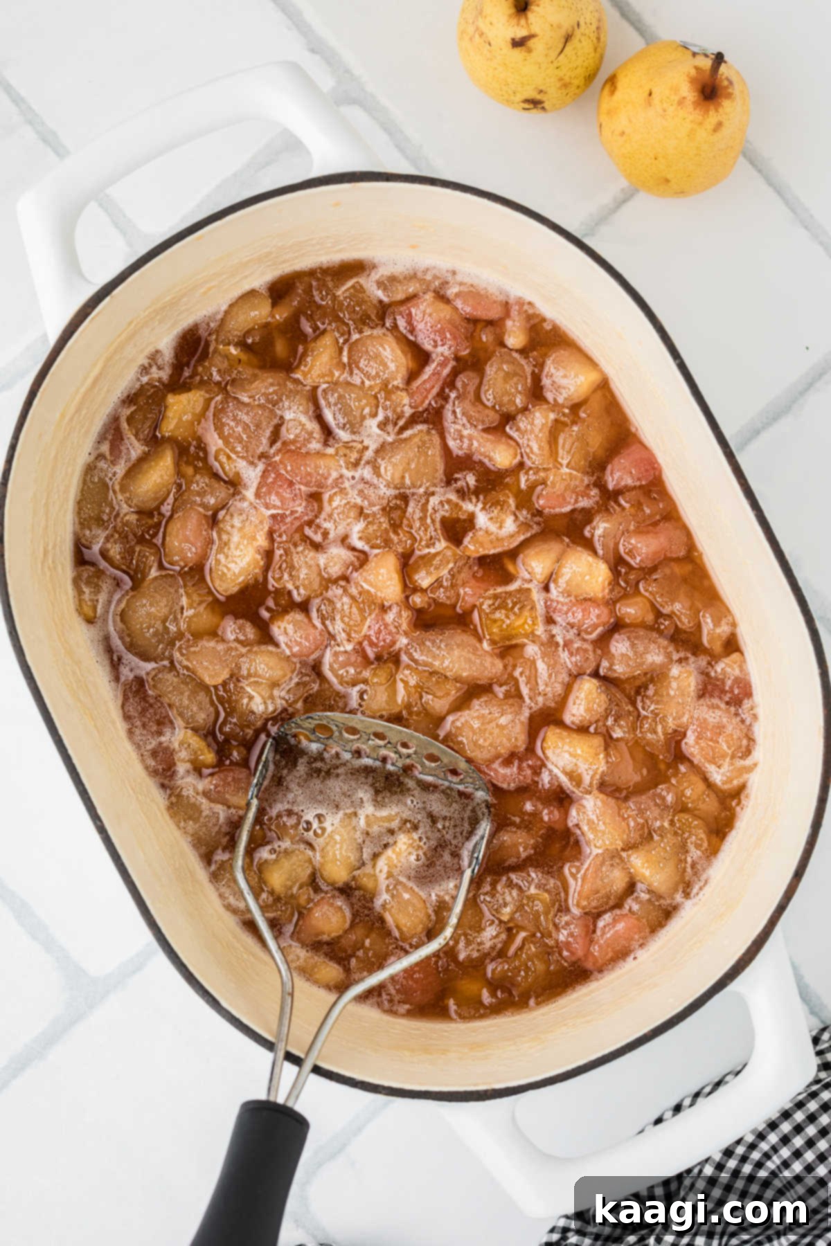 A large pot with pears that have been cooked down and mashed into a honey-like consistency.