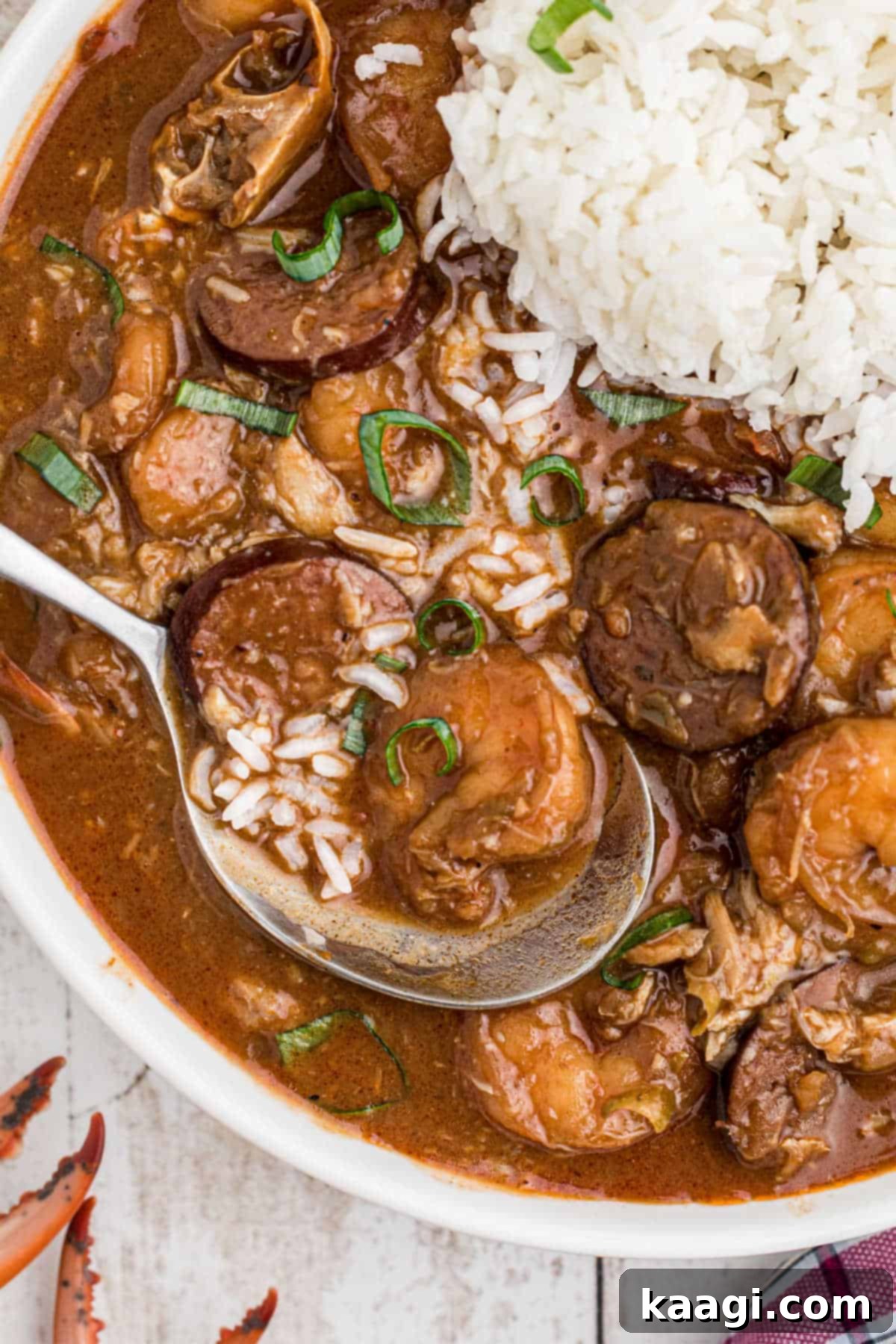A steaming bowl of authentic Louisiana Seafood Gumbo served with white rice and fresh parsley garnish.