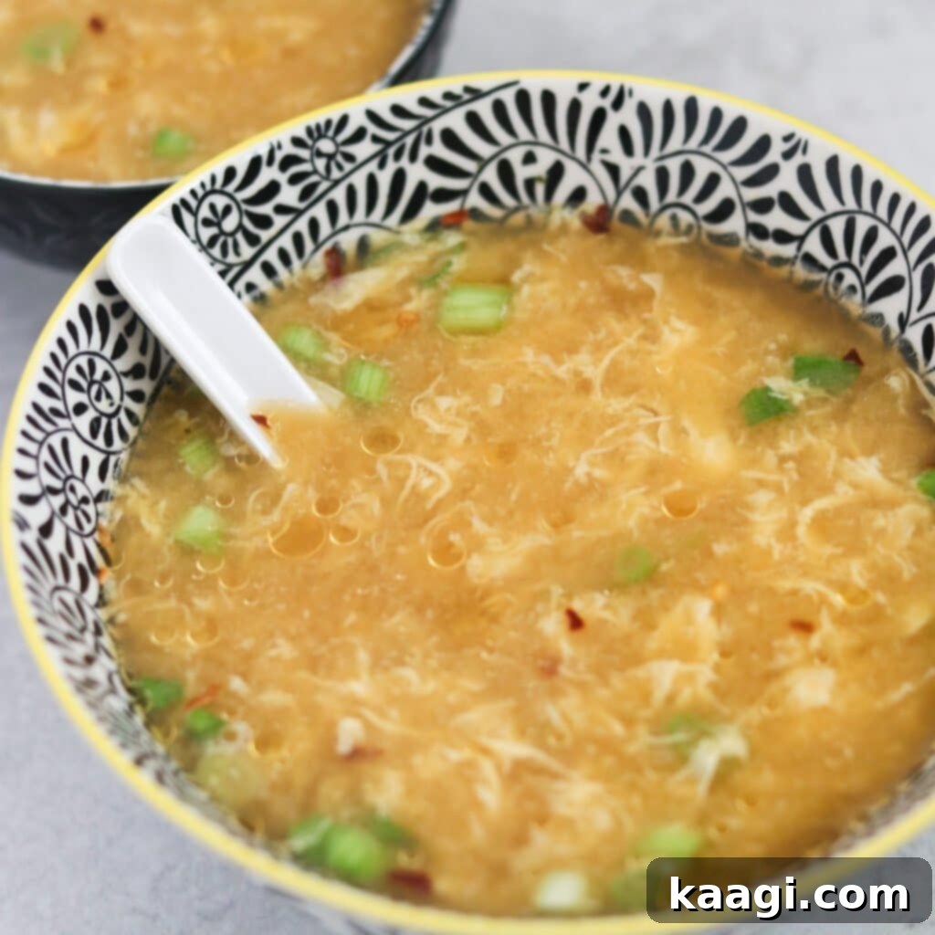 A comforting bowl of golden Instant Pot Egg Drop Soup, garnished with fresh greens.