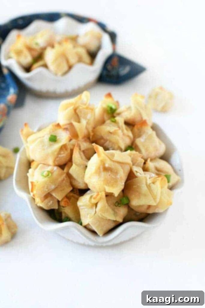 A bowl brimming with crispy, golden oven-baked crab rangoons, a perfect appetizer.