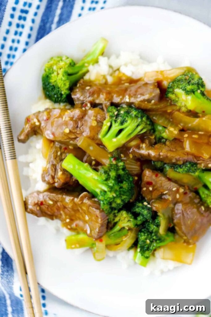 A close-up shot of vibrant Chinese Beef and Broccoli stir-fry, served with chopsticks.