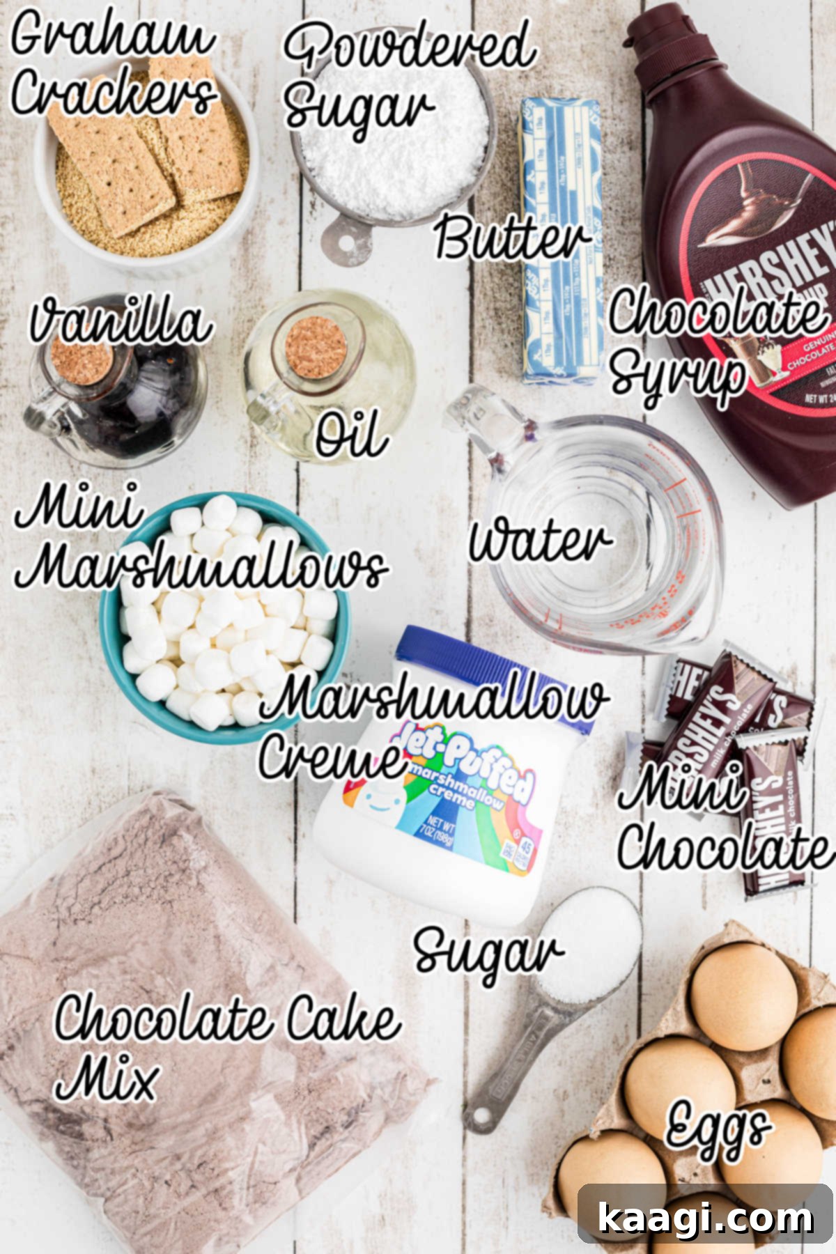 Ingredients laid out on a table for making S'mores cupcakes, including graham crackers, chocolate cake mix, marshmallows, and butter.