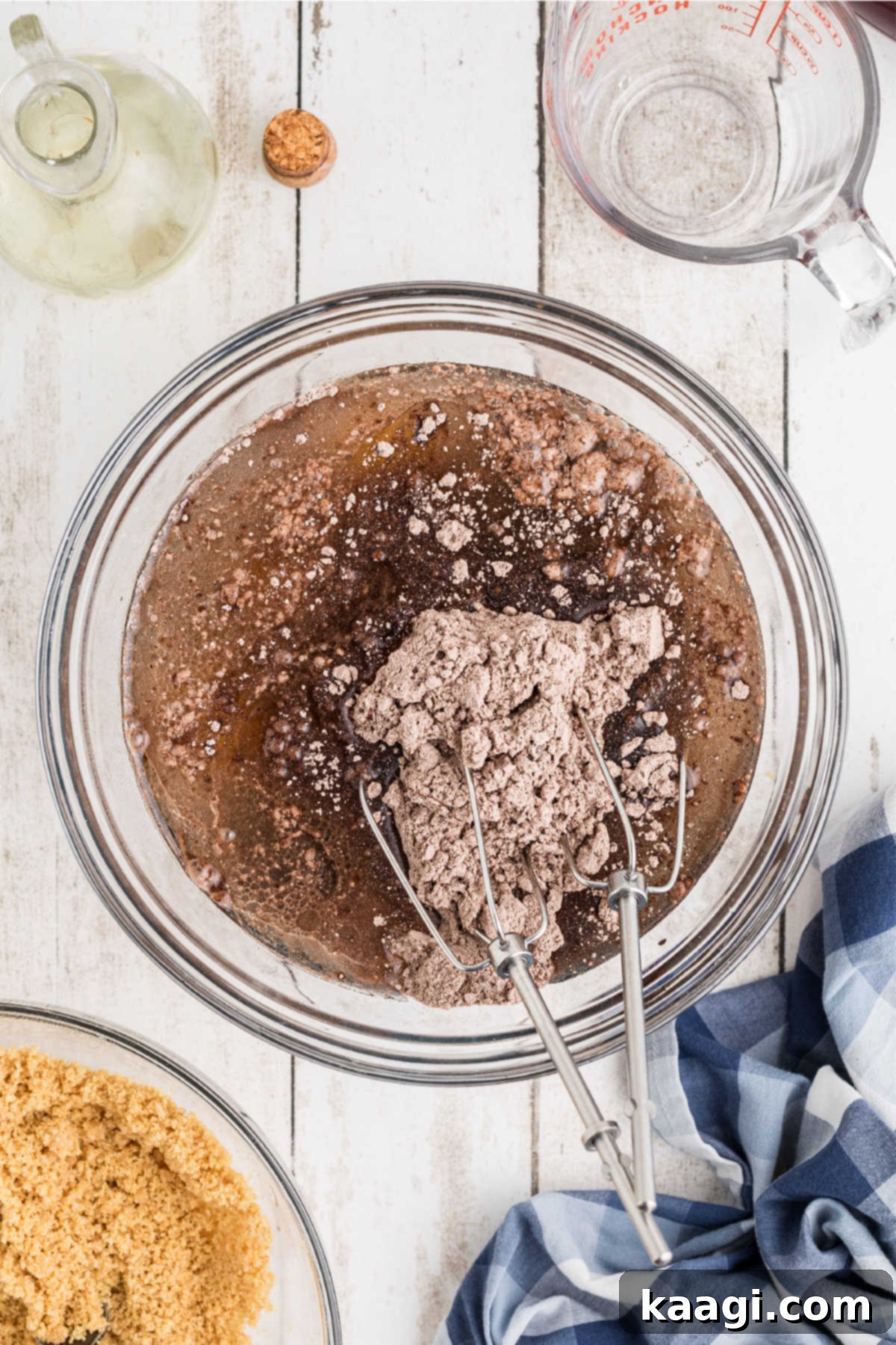 A large mixing bowl filled with chocolate cake mix and other wet ingredients, being prepared according to package directions.