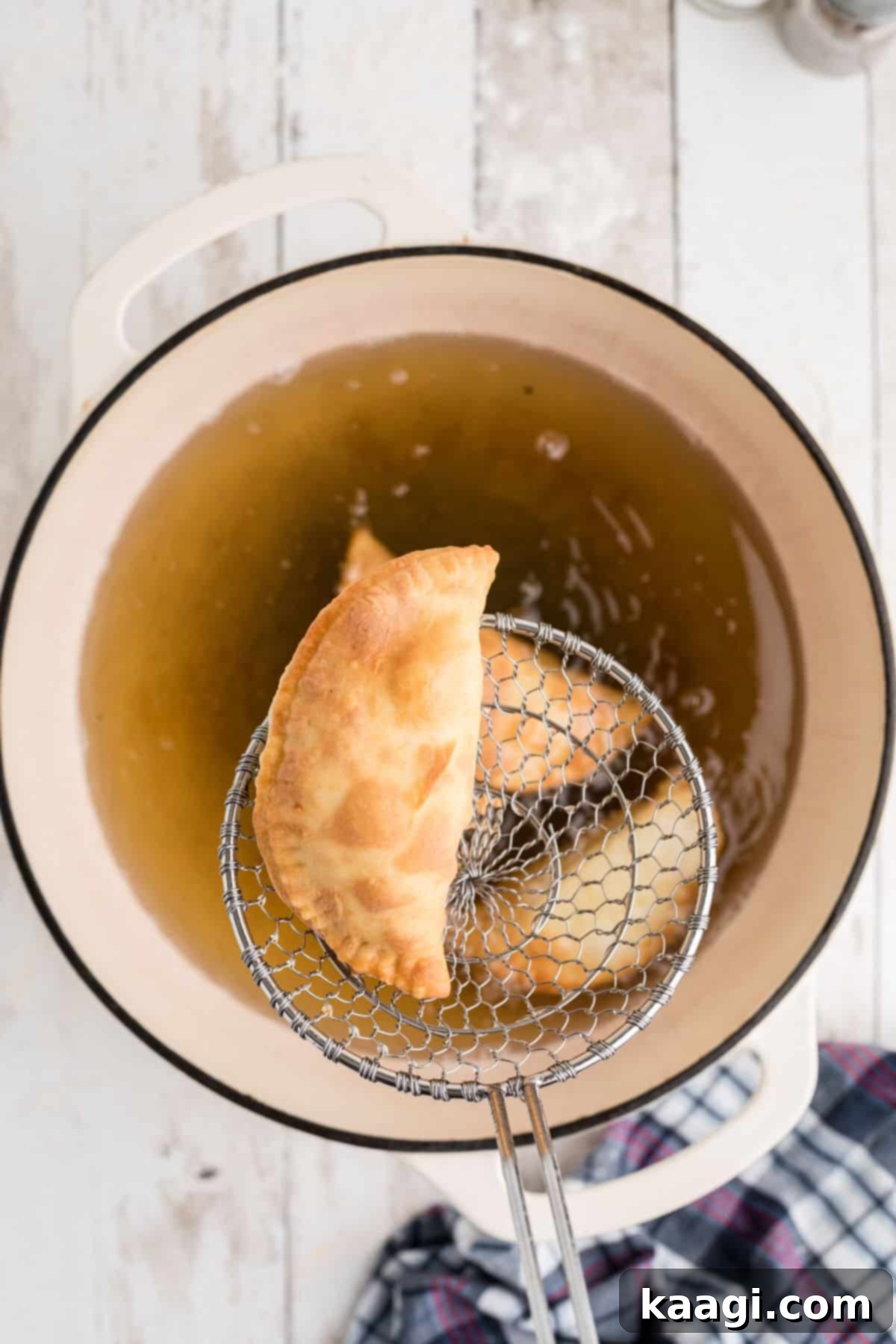 Savory Natchitoches Meat Pies A Louisiana Classic 7 A frying basket lifting golden-brown Natchitoches Meat Pies from hot oil, ready to be drained.