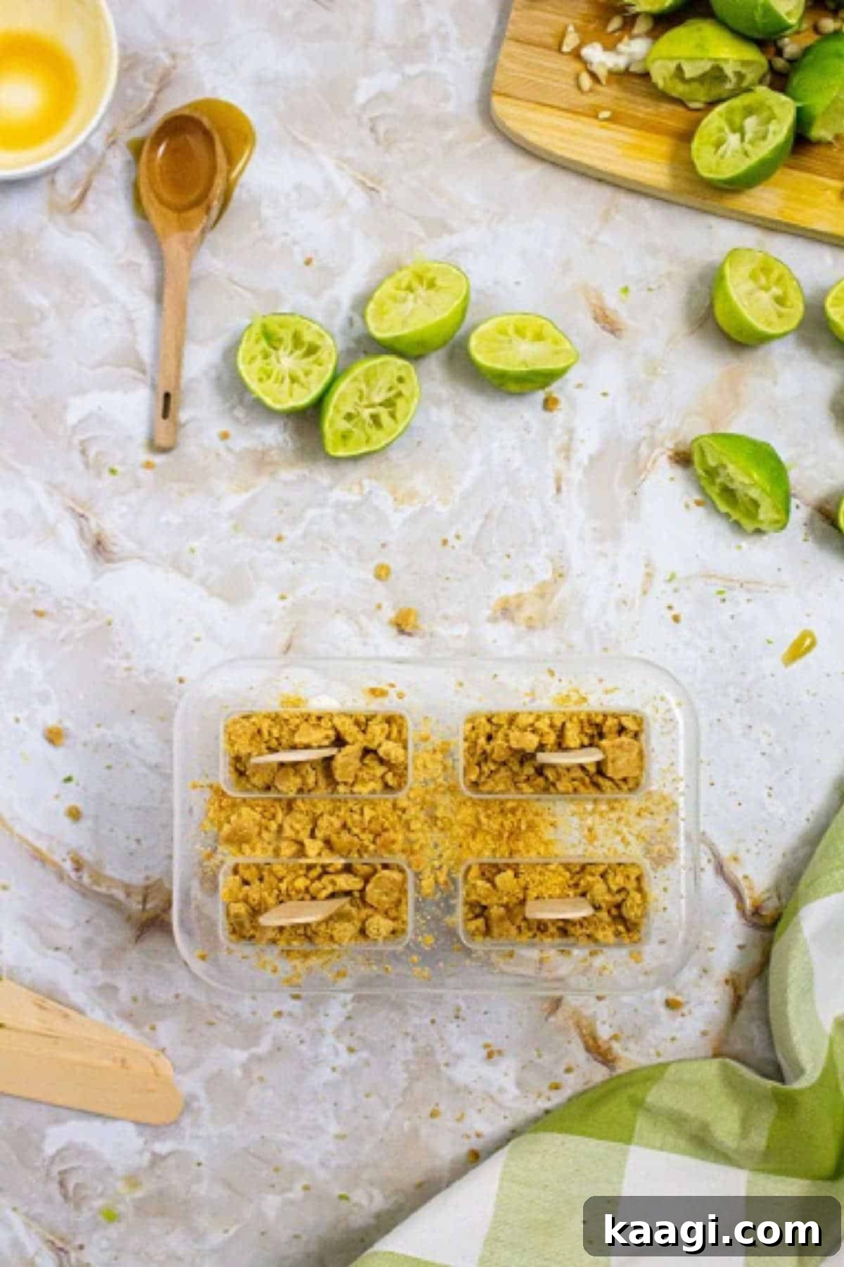 Zesty Key Lime Pops 5 A close-up view of a popsicle mold filled with the Key Lime Pie mixture, topped generously with crushed graham crackers, ready for the freezer.
