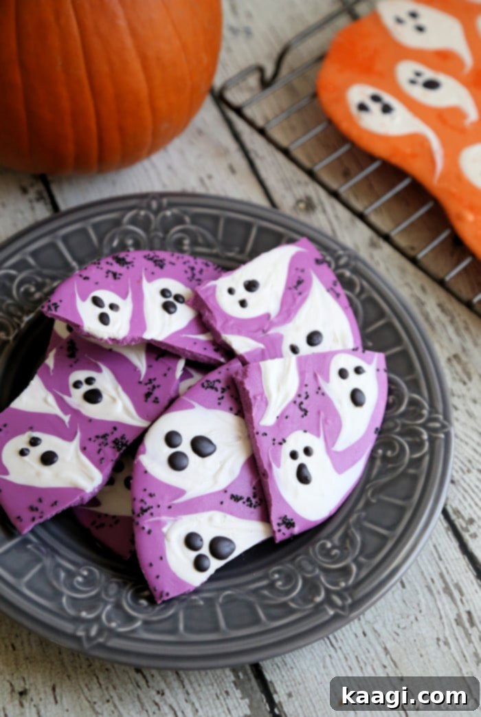 A festive plate of Halloween Ghost Chocolate Bark, adorned with white ghost figures and colorful sprinkles.