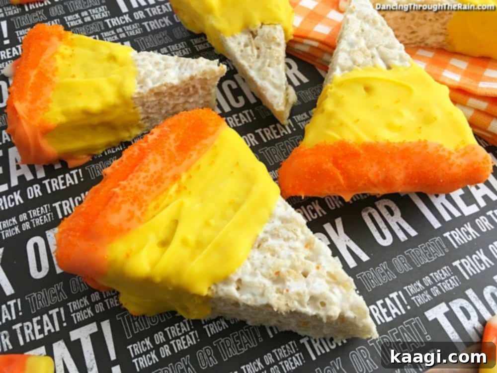 Brightly colored Halloween Candy Corn Krispie Treats, layered in white, orange, and yellow to mimic candy corn.