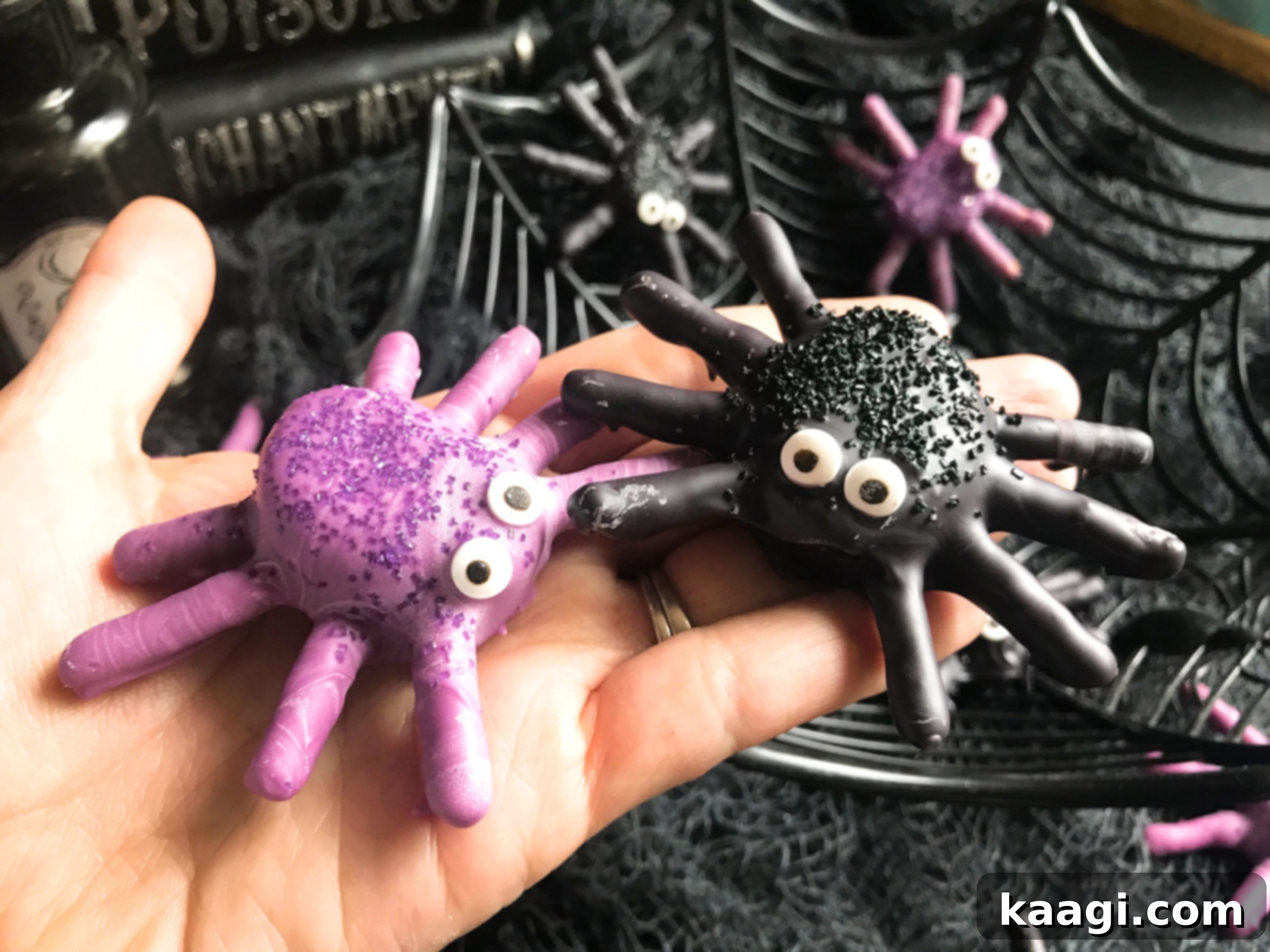 Cute Halloween Candy Dipped Spider Marshmallows with pretzel legs and candy eyes on a white plate.