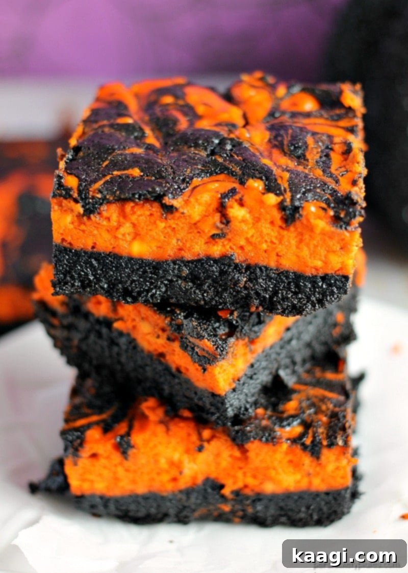 Rich Halloween Swirl Cream Cheese Brownies with vibrant orange cheesecake swirls on a dark chocolate brownie base.