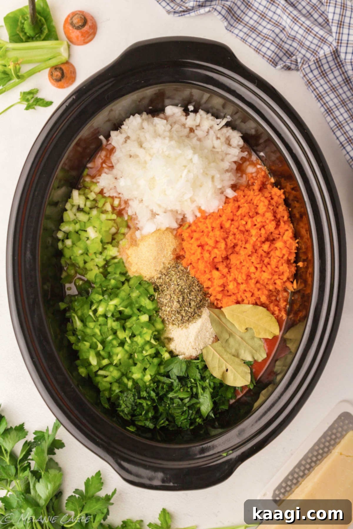 A large slow cooker filled with a rich tomato sauce and various vegetables, ready to be stirred.