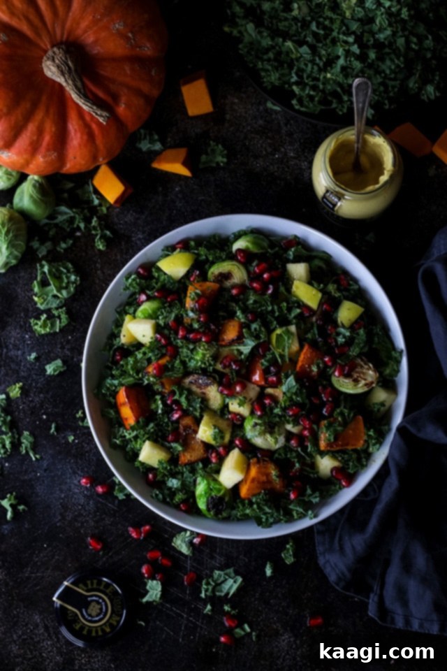 A light and healthy Vegan Fall Harvest Salad with kale, pumpkin, and pomegranate.