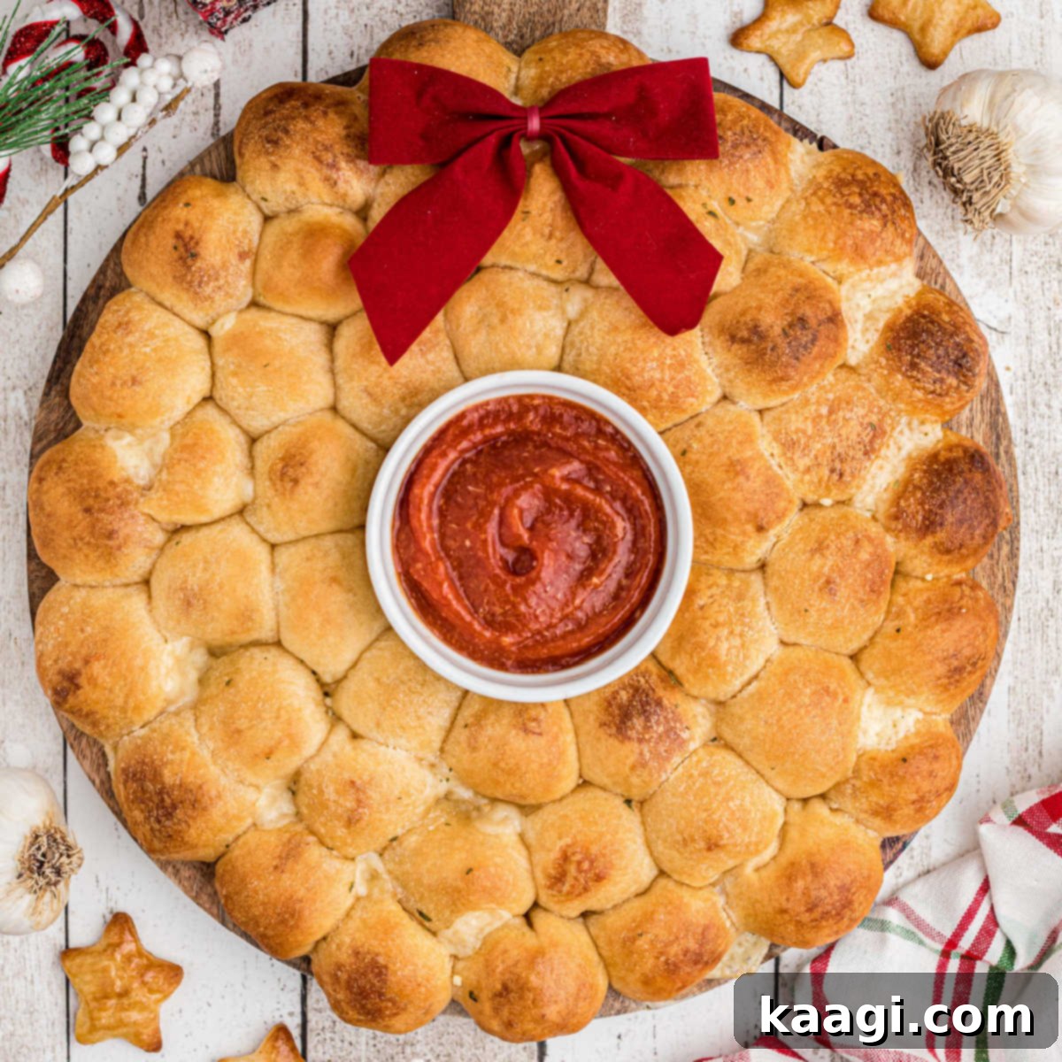 A delicious pull apart bread wreath, filled with cheesy stuffing, ready for Christmas or Thanksgiving.