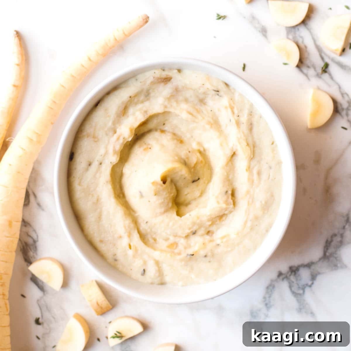 A creamy, smooth parsnip mash, garnished with fresh herbs.