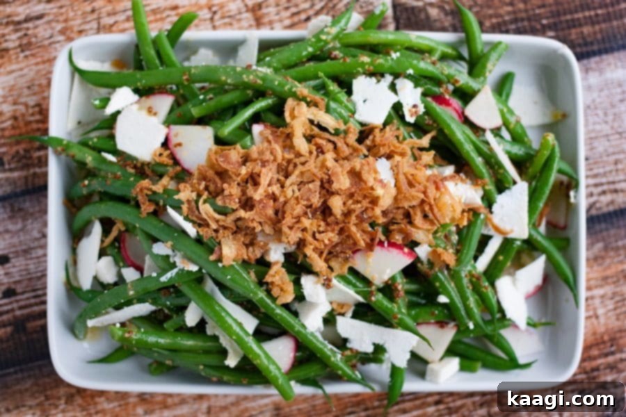 A fresh green bean salad with a generous topping of crispy fried onions.