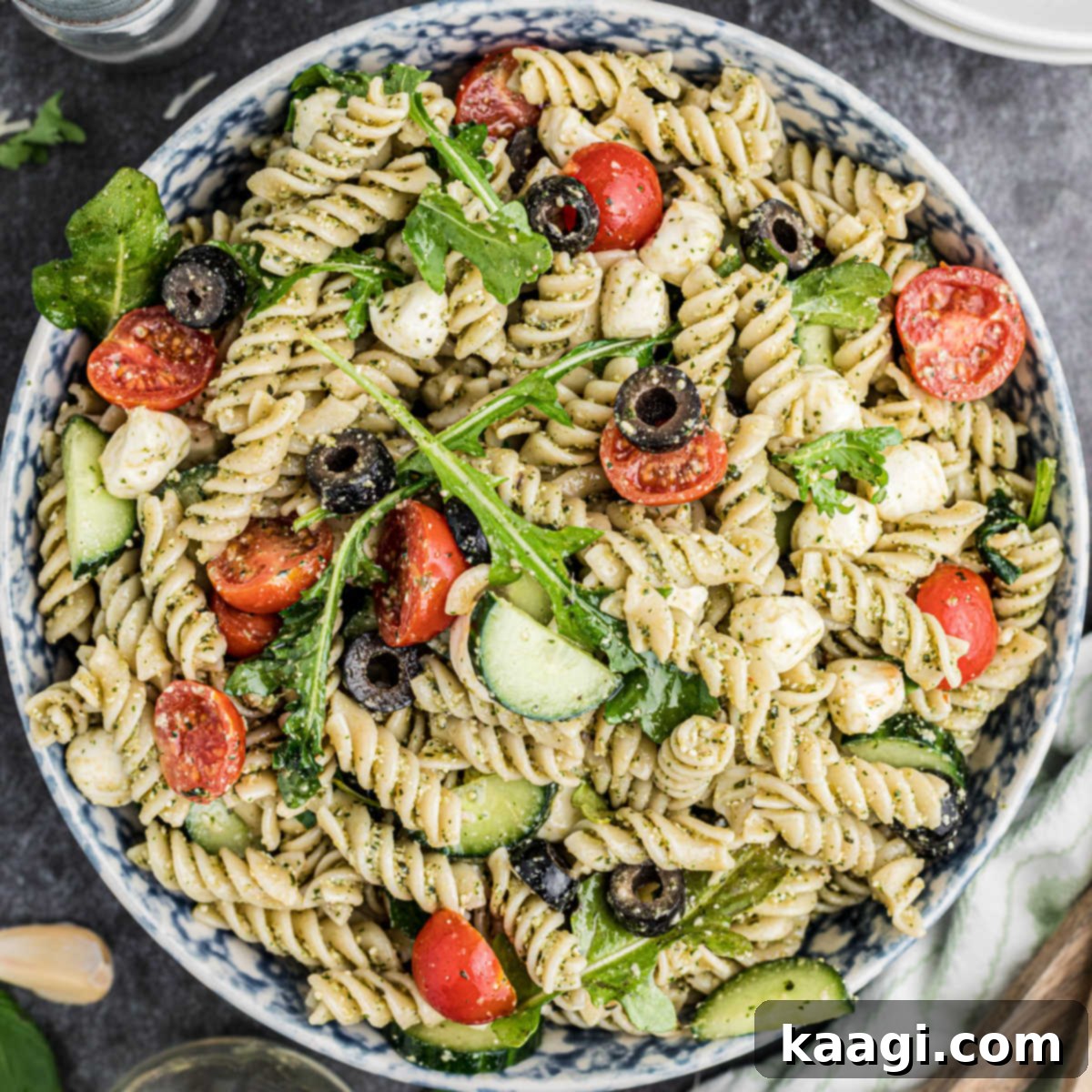 Overhead shot of a full bowl of fresh and flavorful summer pesto pasta salad.
