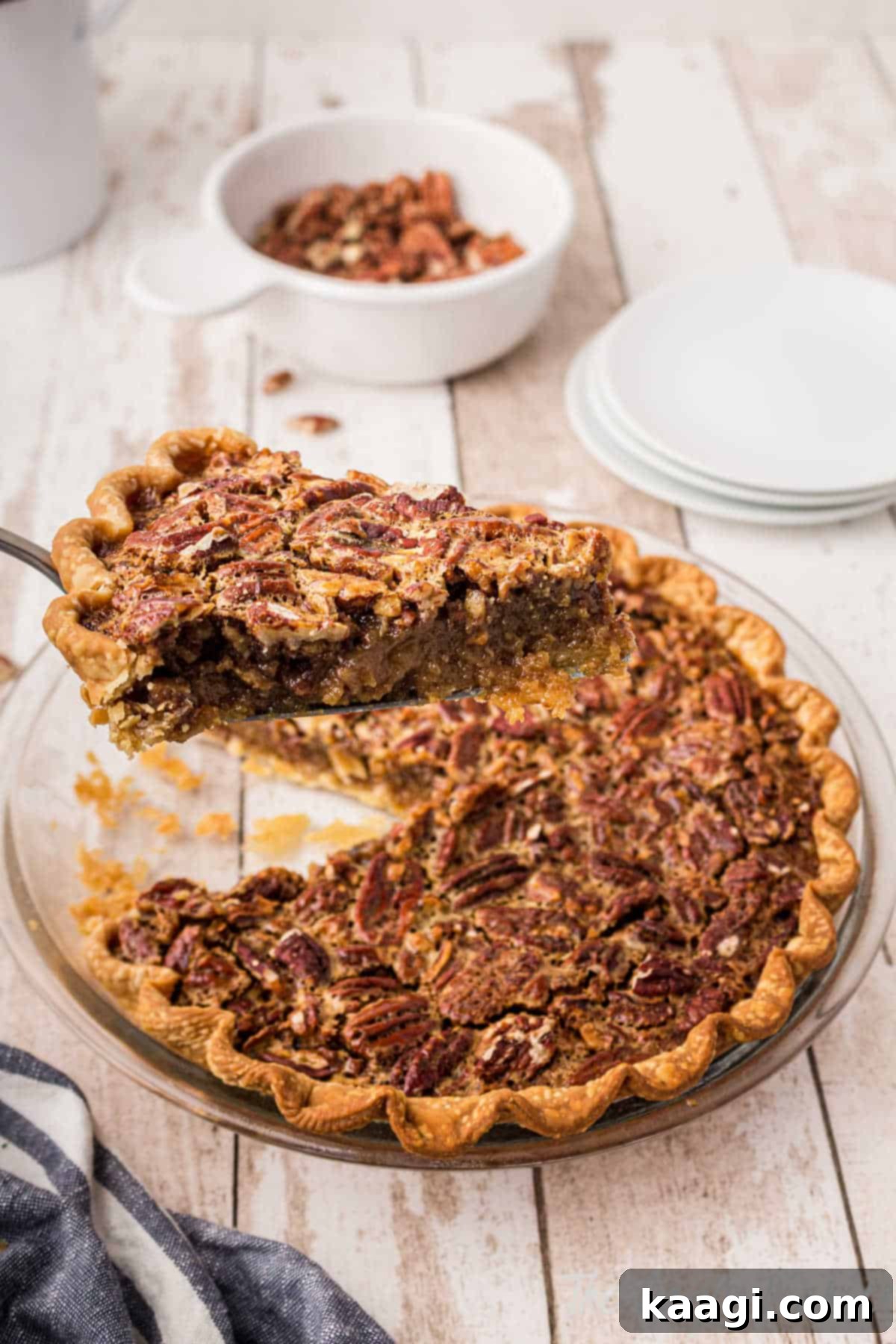 A slice of golden brown Old Fashioned Pecan Pie with a delectable filling, ready to be served from a freshly baked pie.