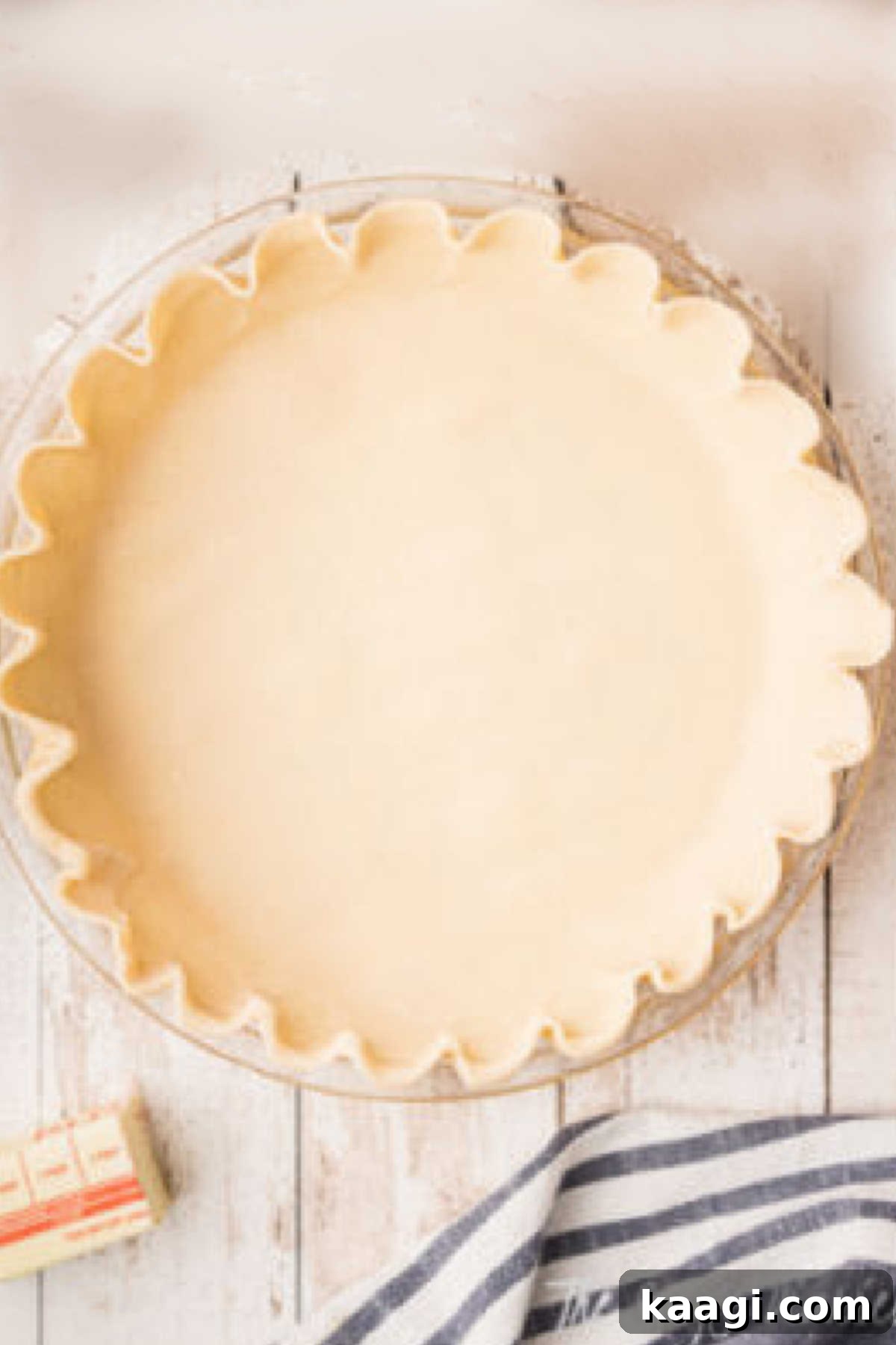 A perfectly prepared pie crust nested within a glass pie dish, chilled and ready for the filling.