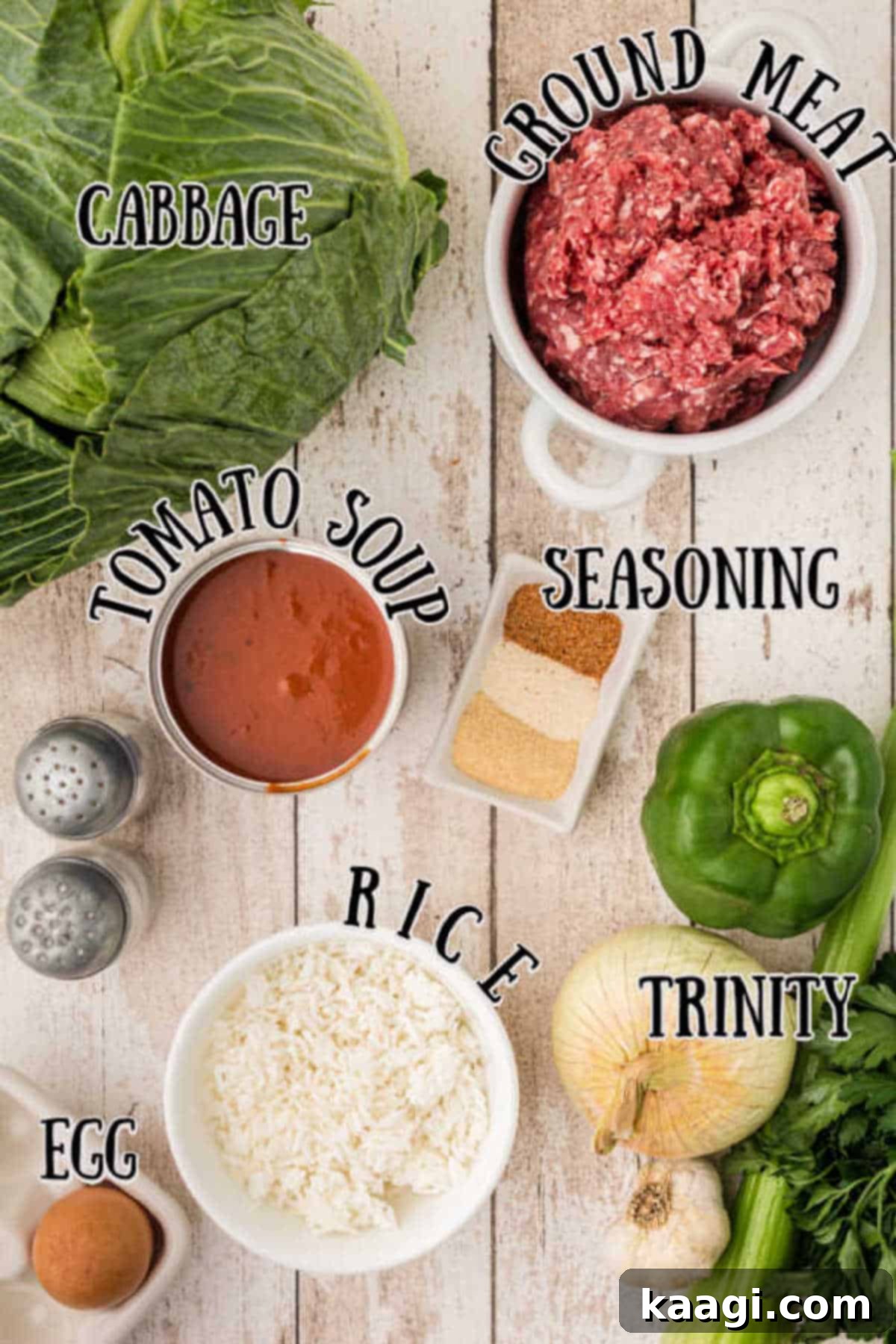 Old-World Cabbage Rolls 3 A vibrant display of fresh ingredients for traditional cabbage rolls, including a large green cabbage, raw ground meat, cooked rice, aromatic vegetables like onion, celery, bell pepper, and garlic, alongside various seasonings.
