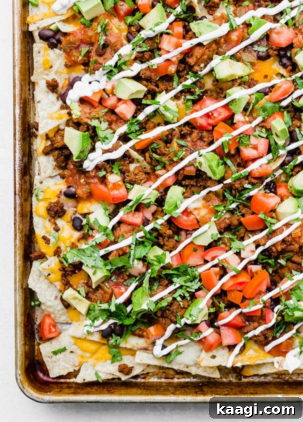 Loaded Nachos piled high with ground beef, cheese, beans, salsa, tomatoes, avocado, and sour cream.