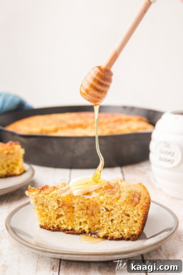 A slice of golden Southern Cornbread with glistening honey drizzled generously on top.