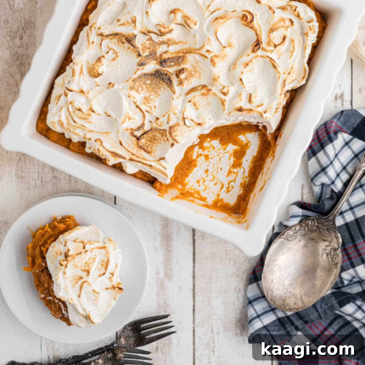Overhead shot of a sweet potato fluff in a dish, with a spoonful removed, revealing its fluffy texture and toasted marshmallow topping.