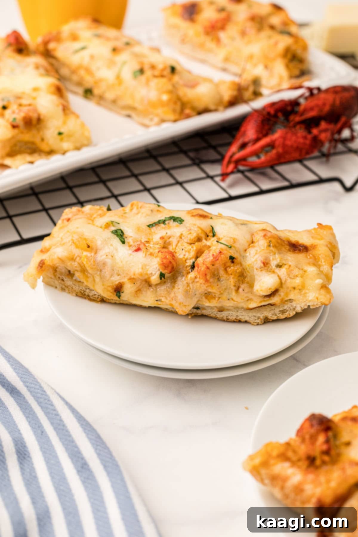 A delectable slice of crawfish bread resting on a plate, with a perfectly cooked crawfish in the background, hinting at its fresh ingredients.