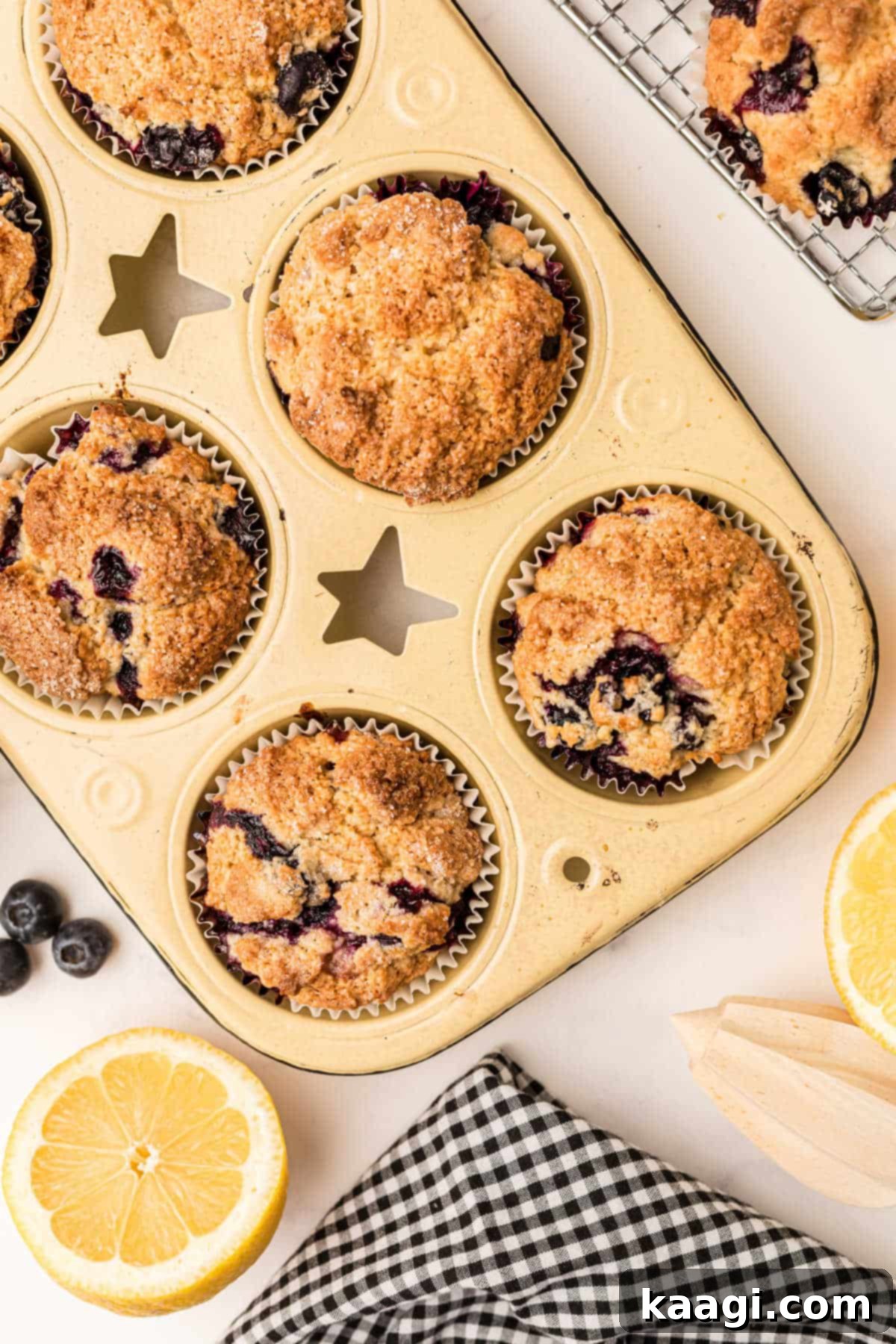 a muffin tin with lemon blueberry muffins cooked