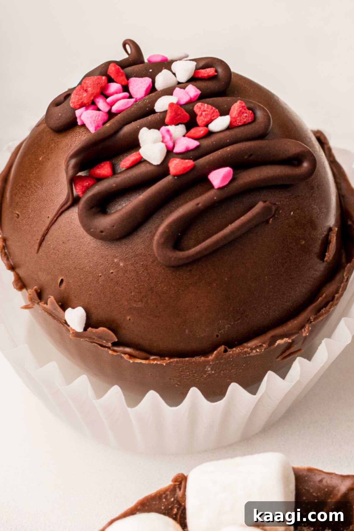 Homemade Hot Chocolate Bomb Magic 6 A close-up image of a hot chocolate bomb beautifully decorated with festive Valentine's Day sprinkles on top.