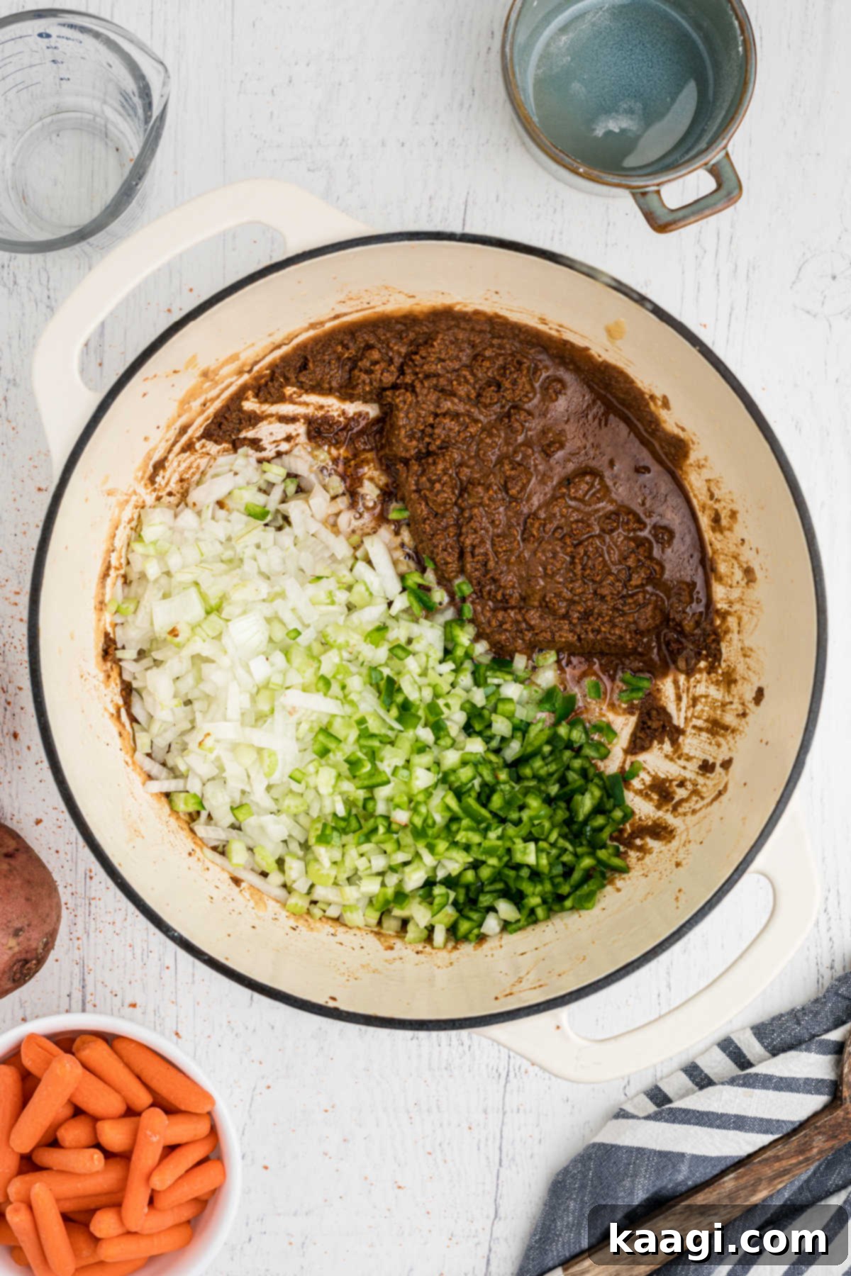 Diced onions and peppers added to a pot with a dark roux.