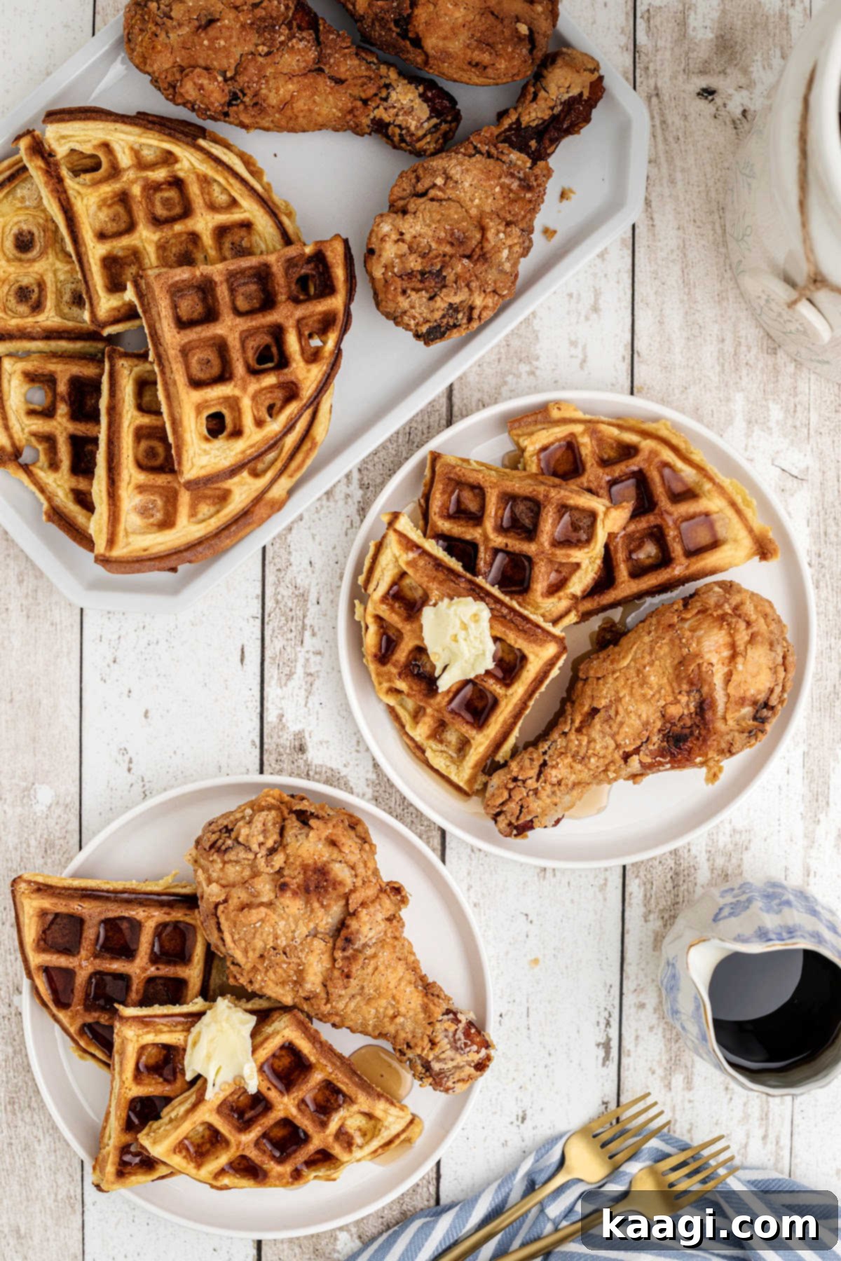 A dish of fried chicken and waffles with syrup on them on dished out plates