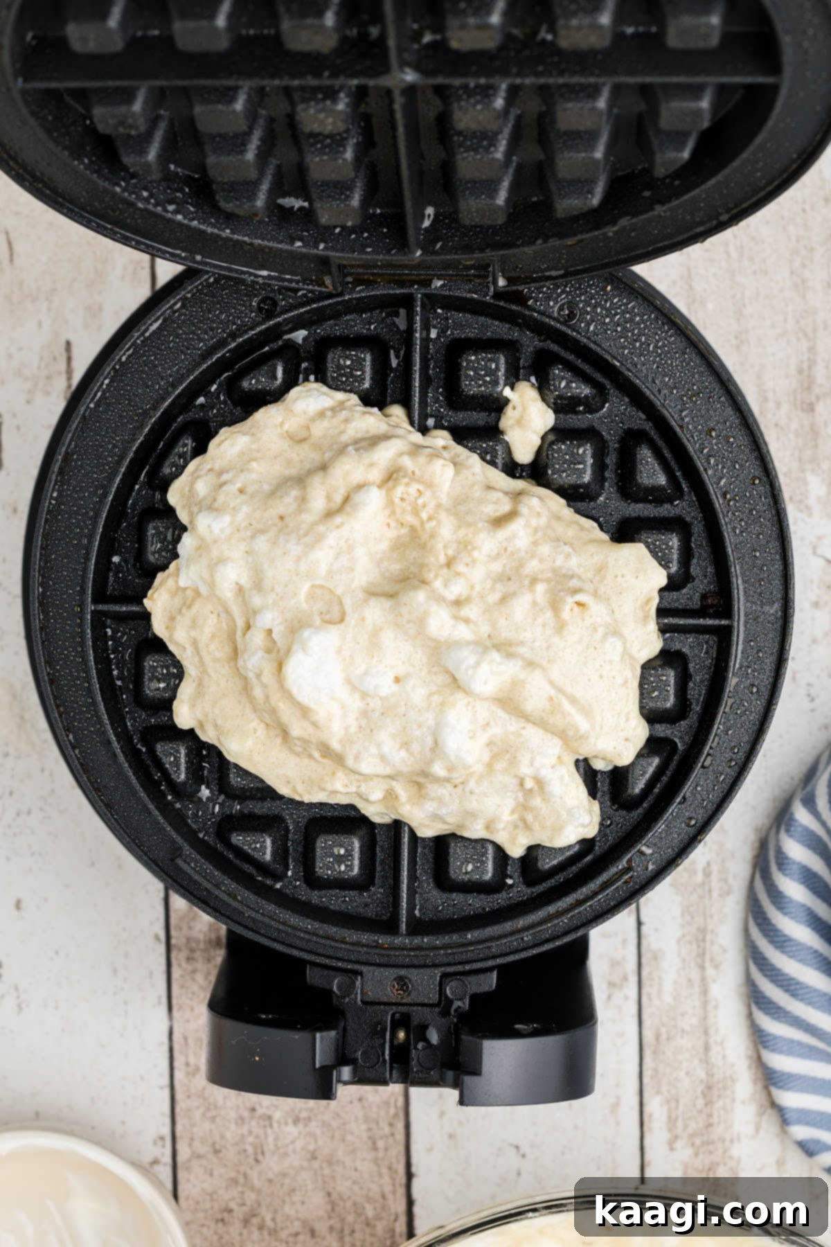 Waffle batter added to a waffle iron.
