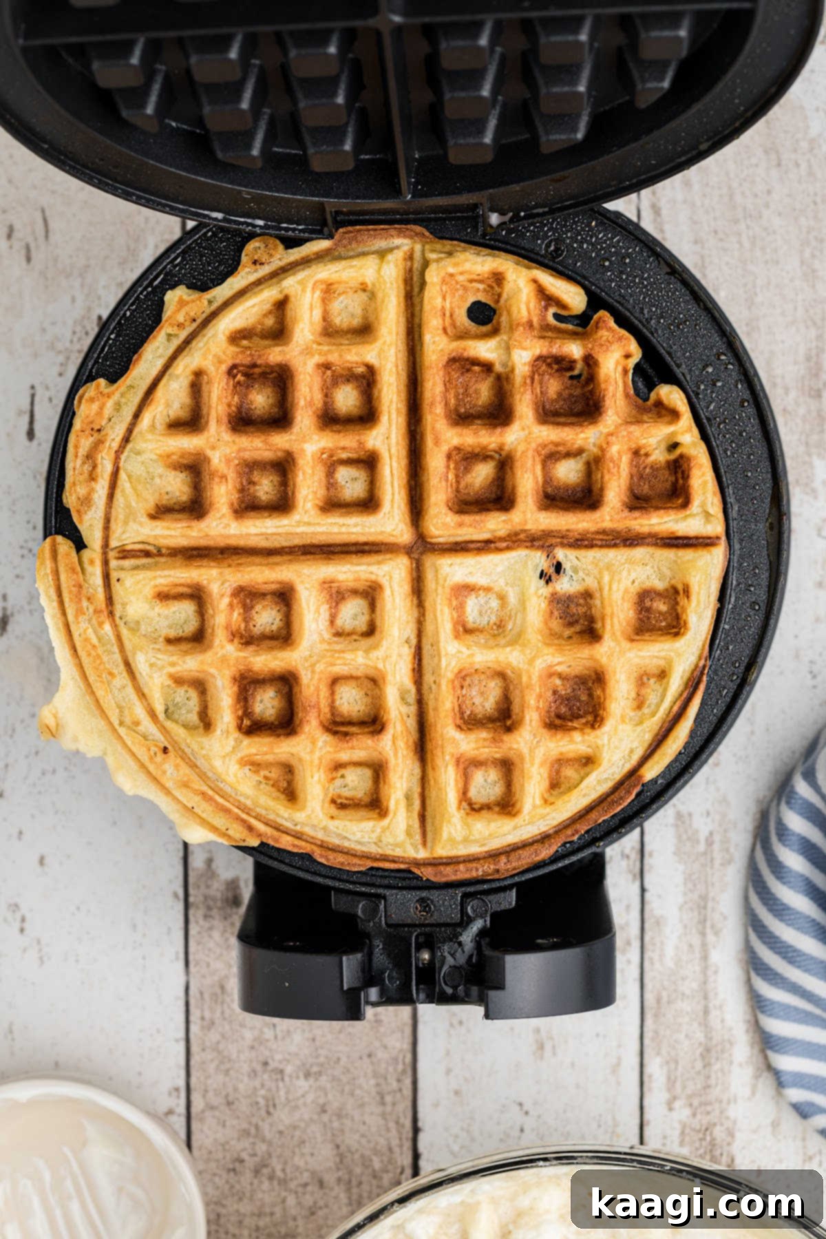 A cooked waffle on a waffle iron.