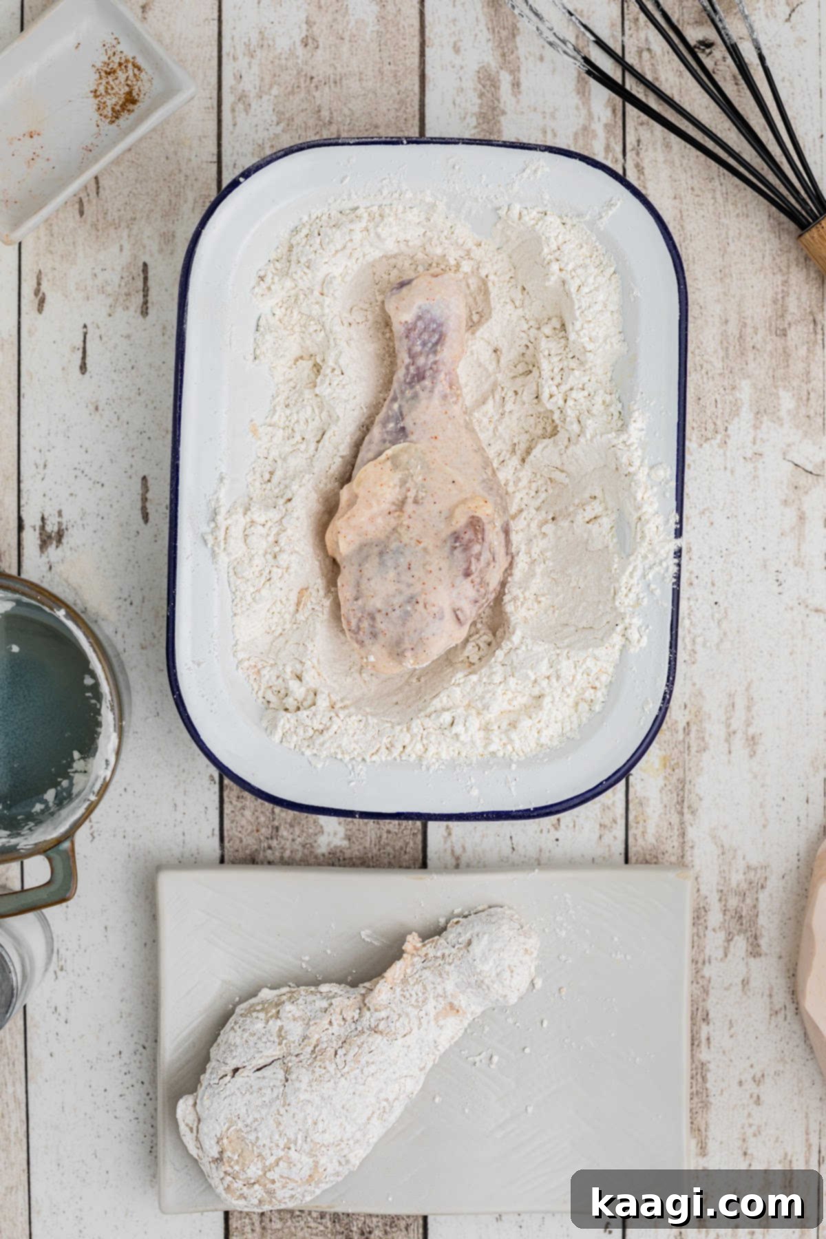 Chicken pieces being rolled in a flour mixture.