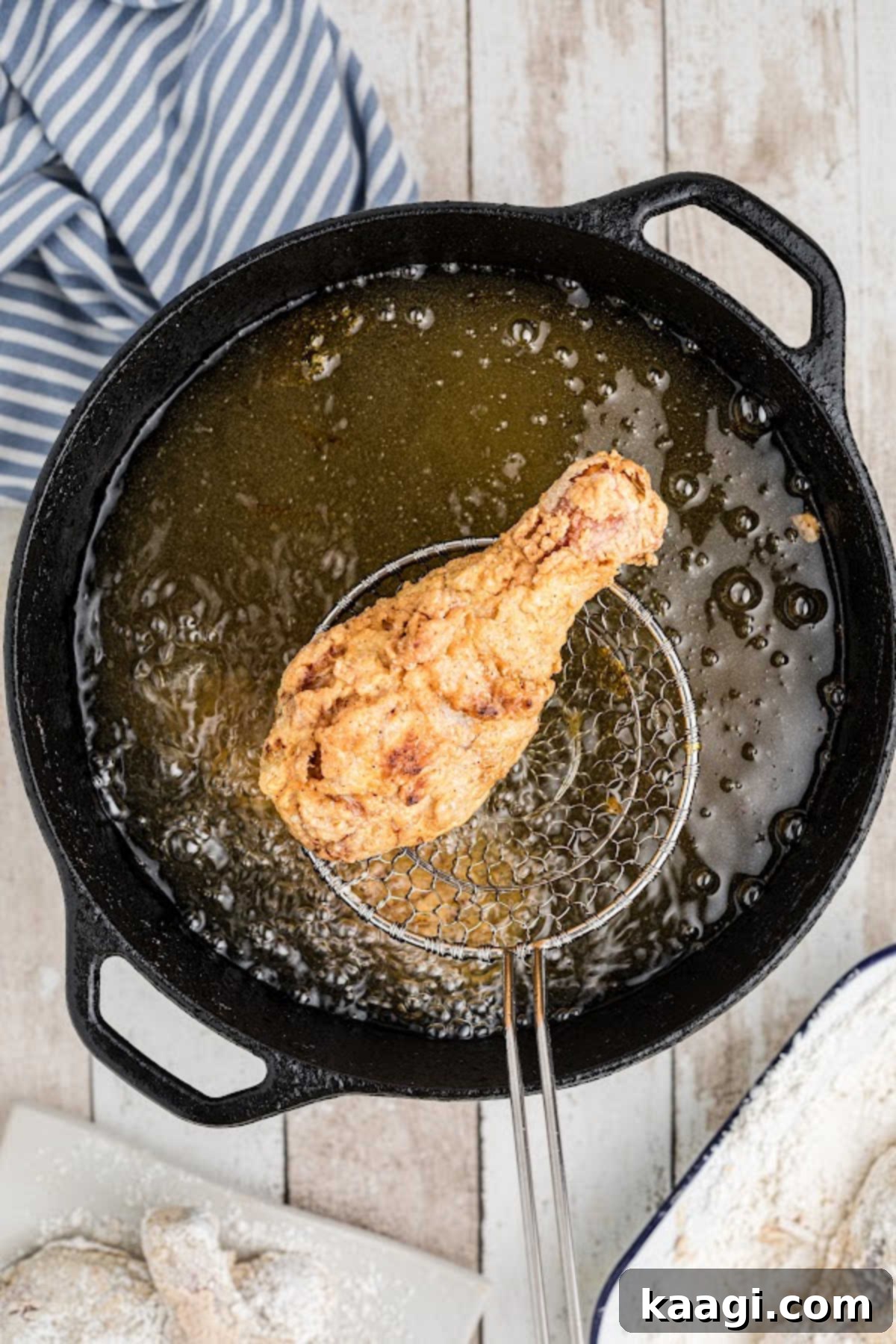 Chicken frying in a black pot.