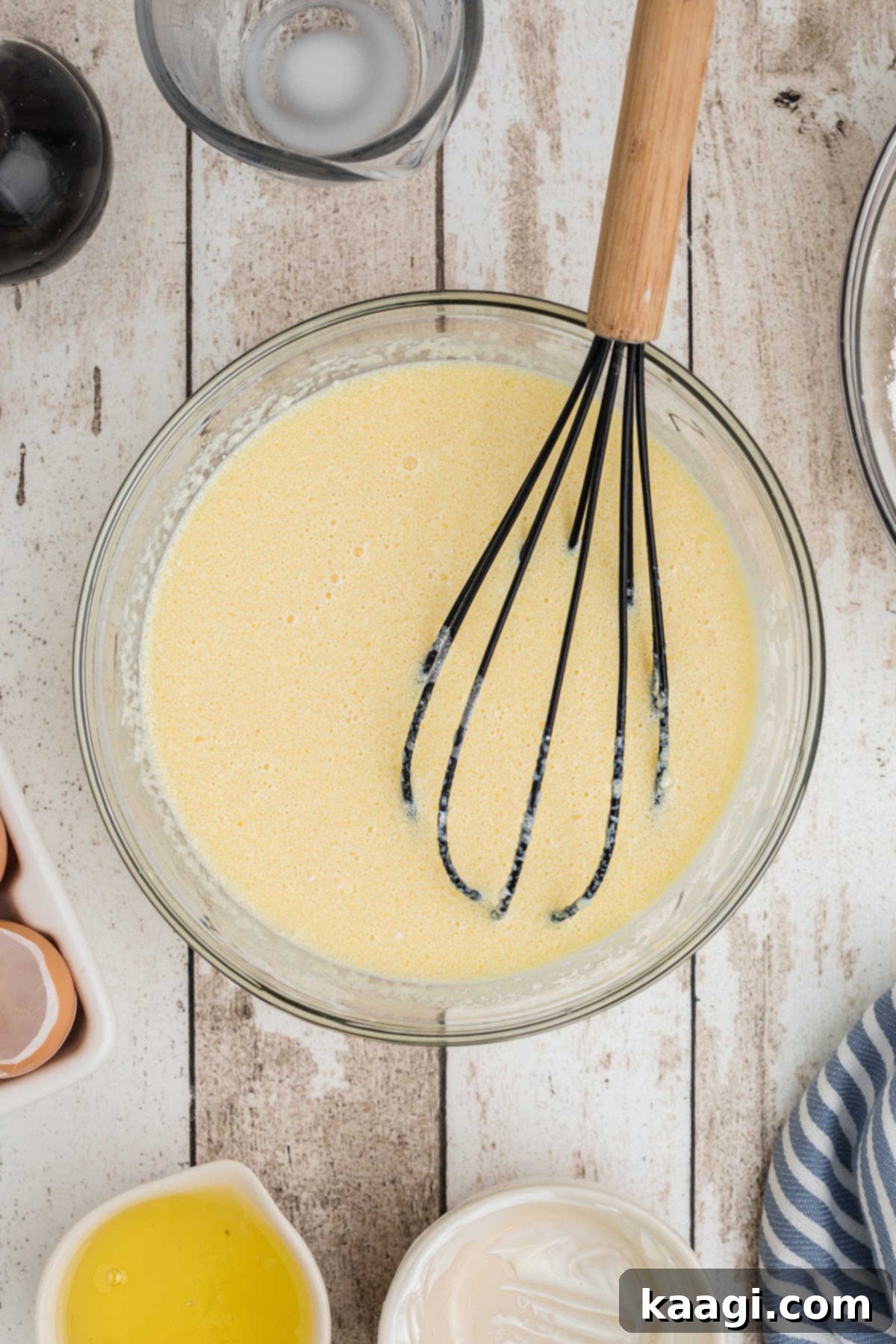A large mixing bowl with a butter, egg and vanilla mixture.