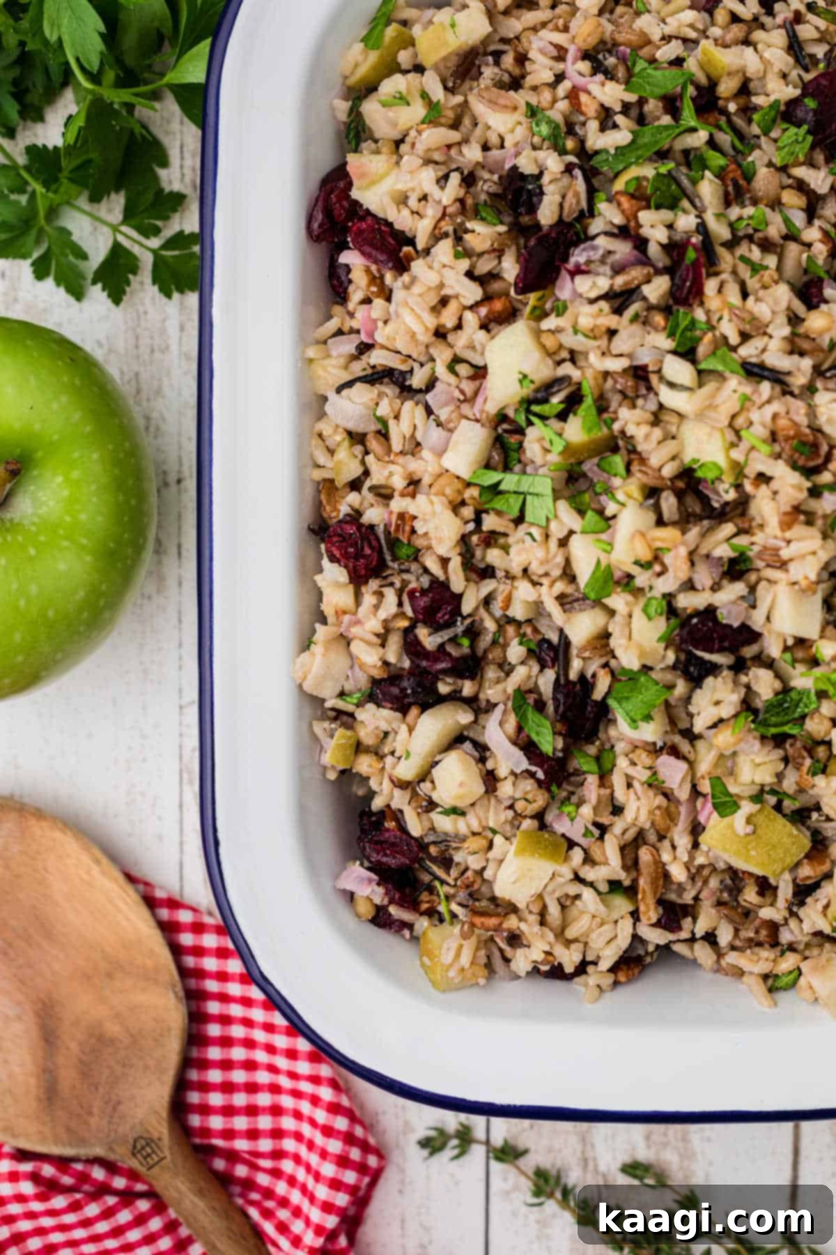 A close-up of a corner of the cranberry apple rice pilaf with a spoon on the side, ready to be served, showcasing vibrant colors and textures.