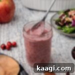 Crimson Vinaigrette 6 A clear glass jar filled with reddish-purple cranberry vinaigrette, ready for serving.