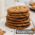 Buttery Crisp Delights 8 A stack of butter crunch cookies with a plate of more cookies in the background.