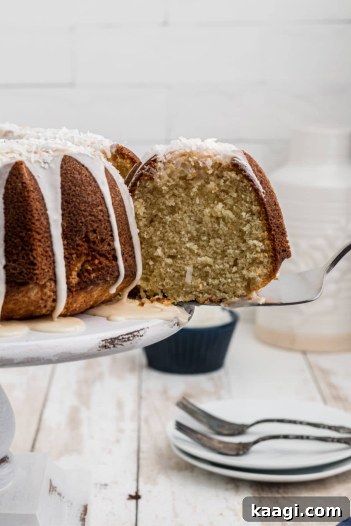 a slice of louisiana crunch cake being taken out of the whole cake using a cake server