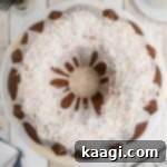 a louisiana crunch cake on a cake stand looking down from overhead, with icing and coconut