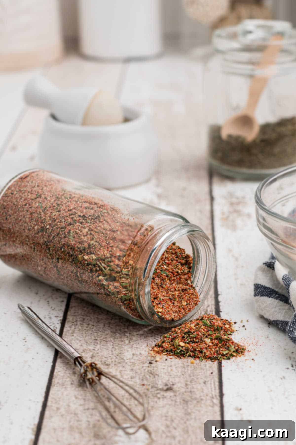 An overturned jar brimming with homemade Creole seasoning, spilling its aromatic contents slightly.