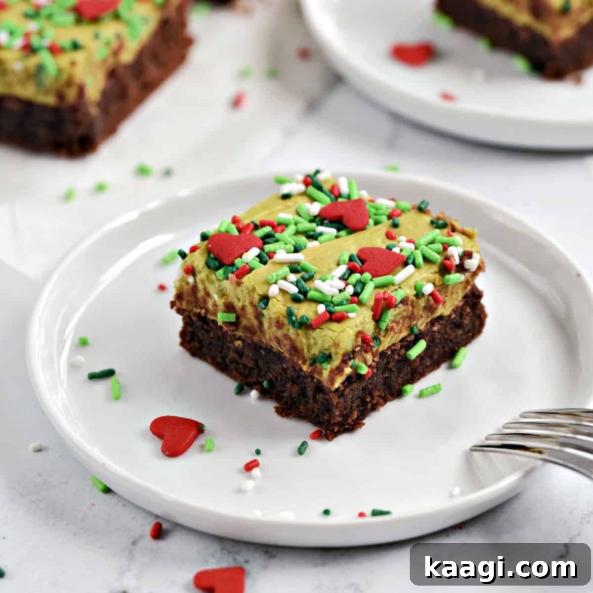 76 Effortless Christmas Goodies 11 Grinch Brownies with green frosting and red heart sprinkles