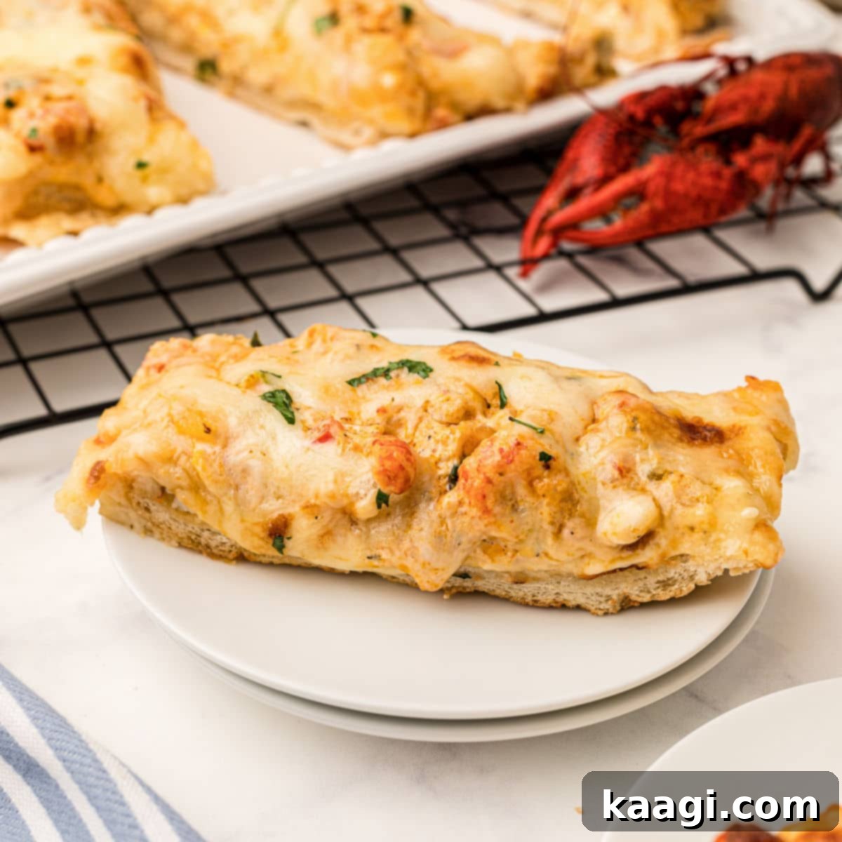 a slice of crawfish bread on a plate with a cooked crawfish behind