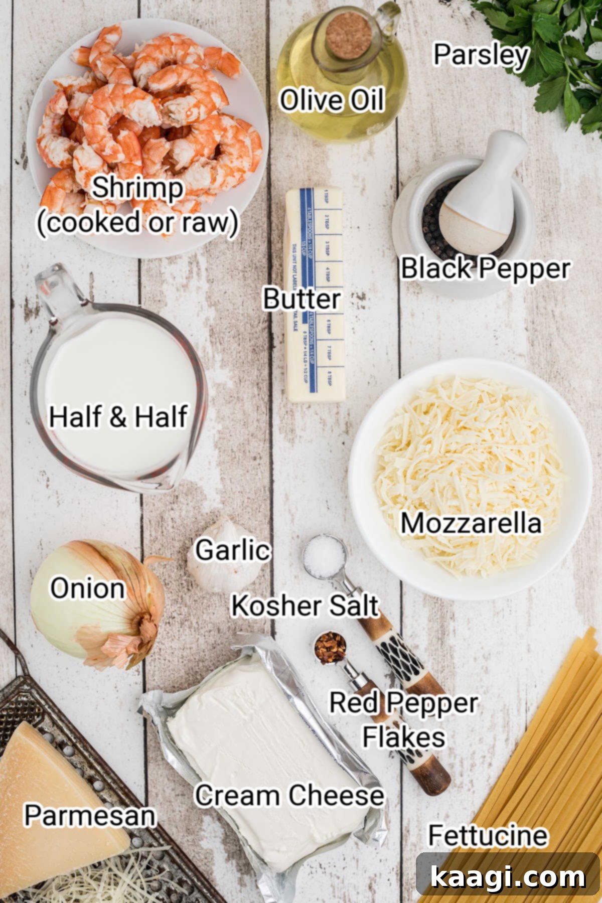 Creamy Garlic Shrimp Pasta Bake 3 Laid out ingredients for a shrimp alfredo bake, including pasta, shrimp, cheese, butter, cream, and fresh herbs.