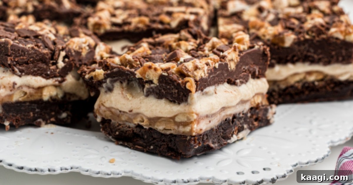 The Only 5 Brownie Recipes You'll Ever Need 3 Close up of a layered Snickers brownie, showcasing chocolate, peanut caramel, and nougat layers, a truly irresistible brownie recipe.
