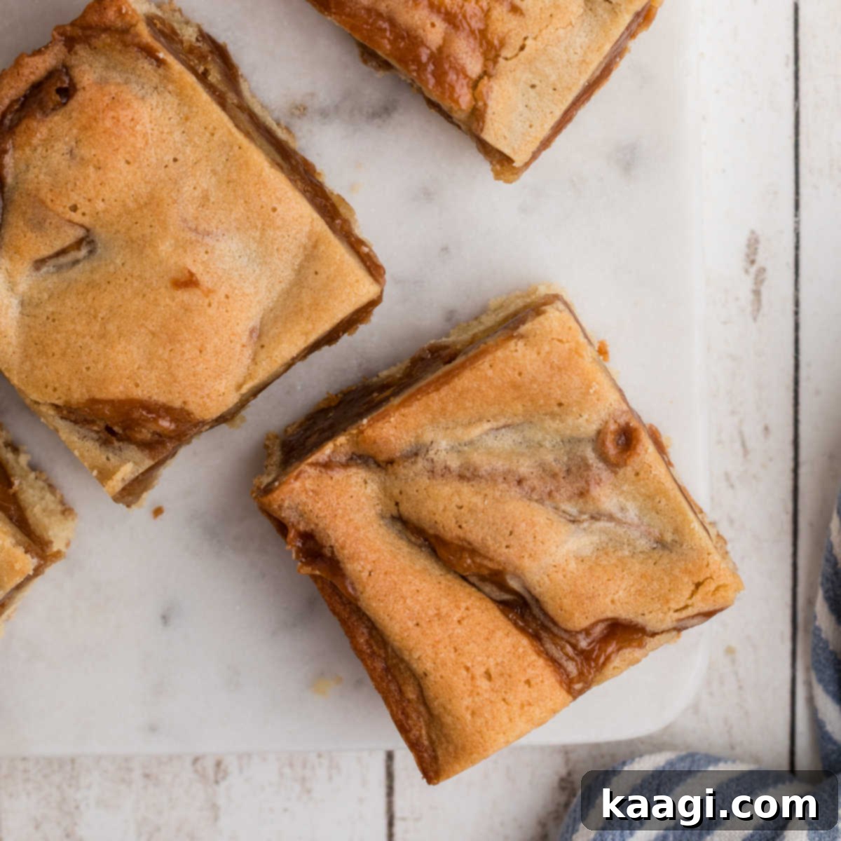 The Only 5 Brownie Recipes You'll Ever Need 8 Overhead close-up view of a pan of delicious caramel swirl blondies on a rustic wooden board, a perfect brownie alternative.