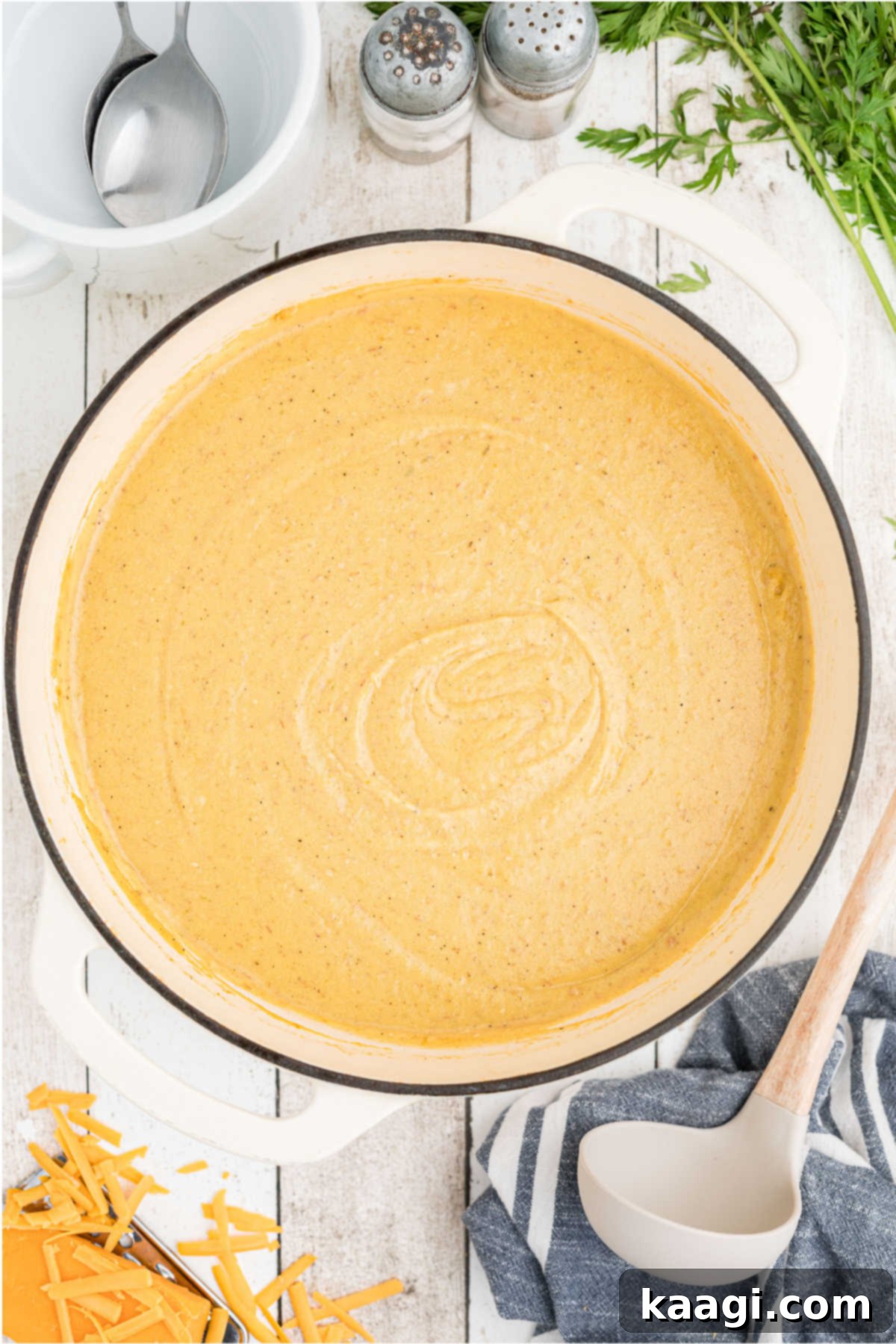 A large Dutch oven full of steaming, creamy copycat Saltgrass baked potato soup, ready to be served, showcasing its inviting texture.