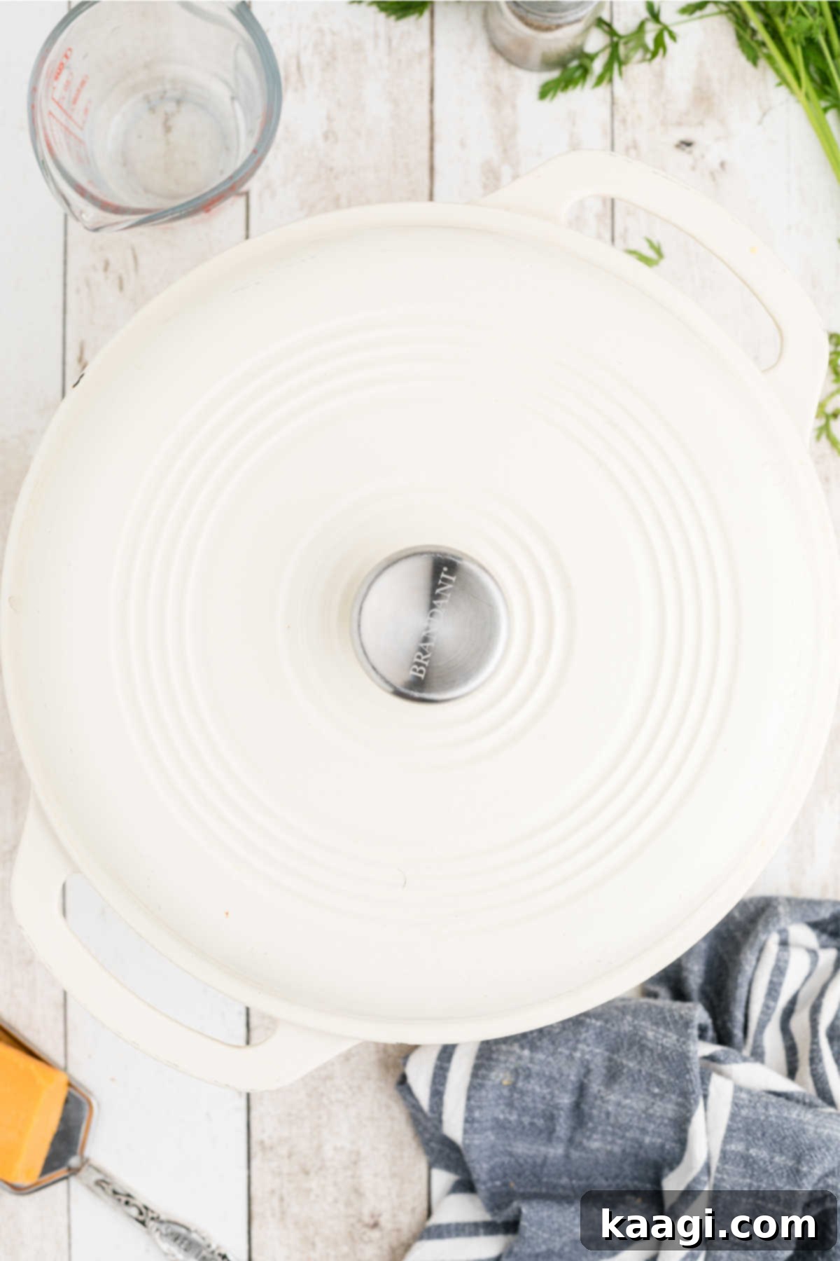 The lid placed securely on top of a large Dutch oven, indicating the simmering phase of the potato soup, allowing flavors to meld and potatoes to soften.
