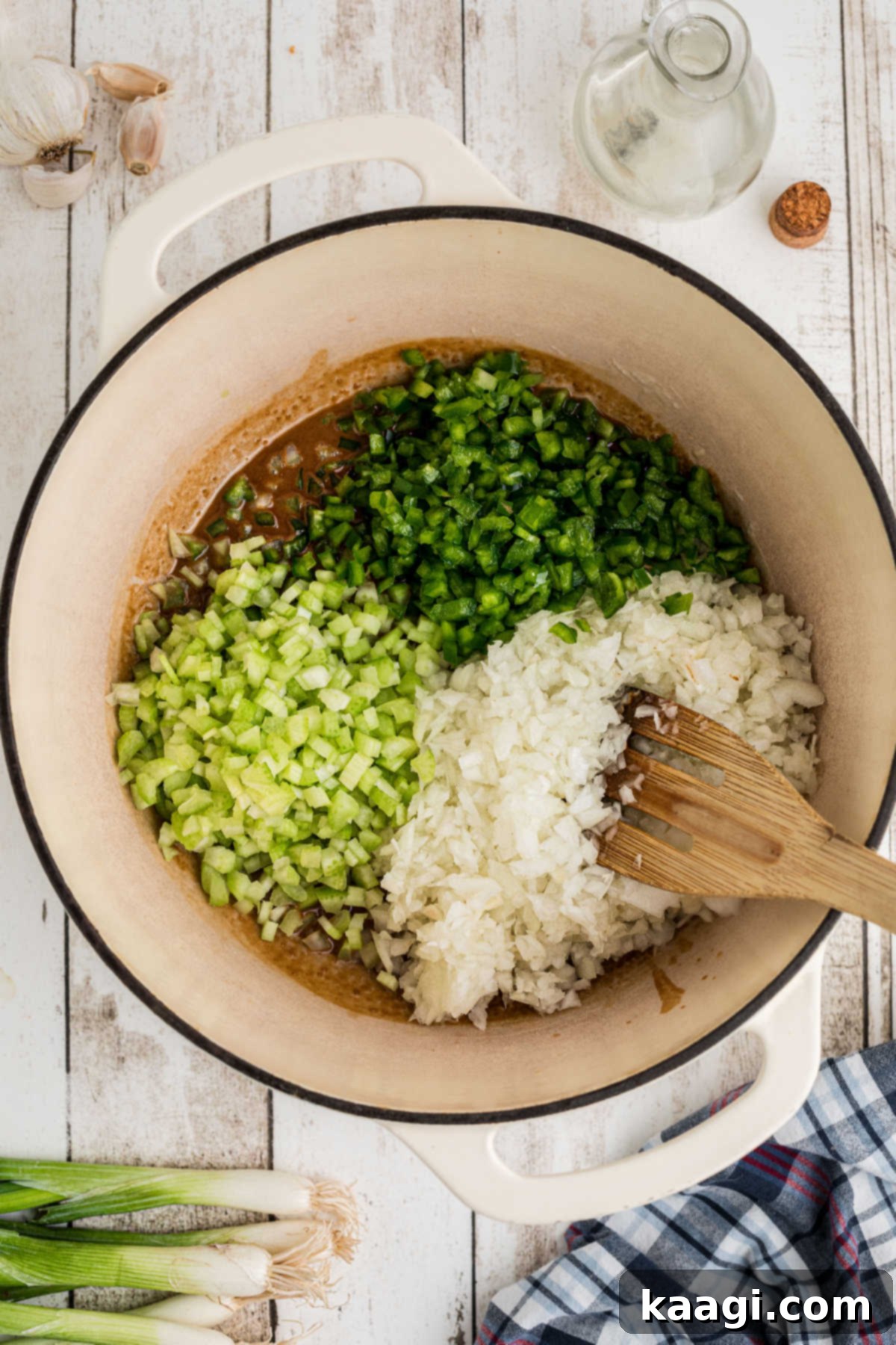 Onions, bell peppers and celery added to a large Dutch oven.