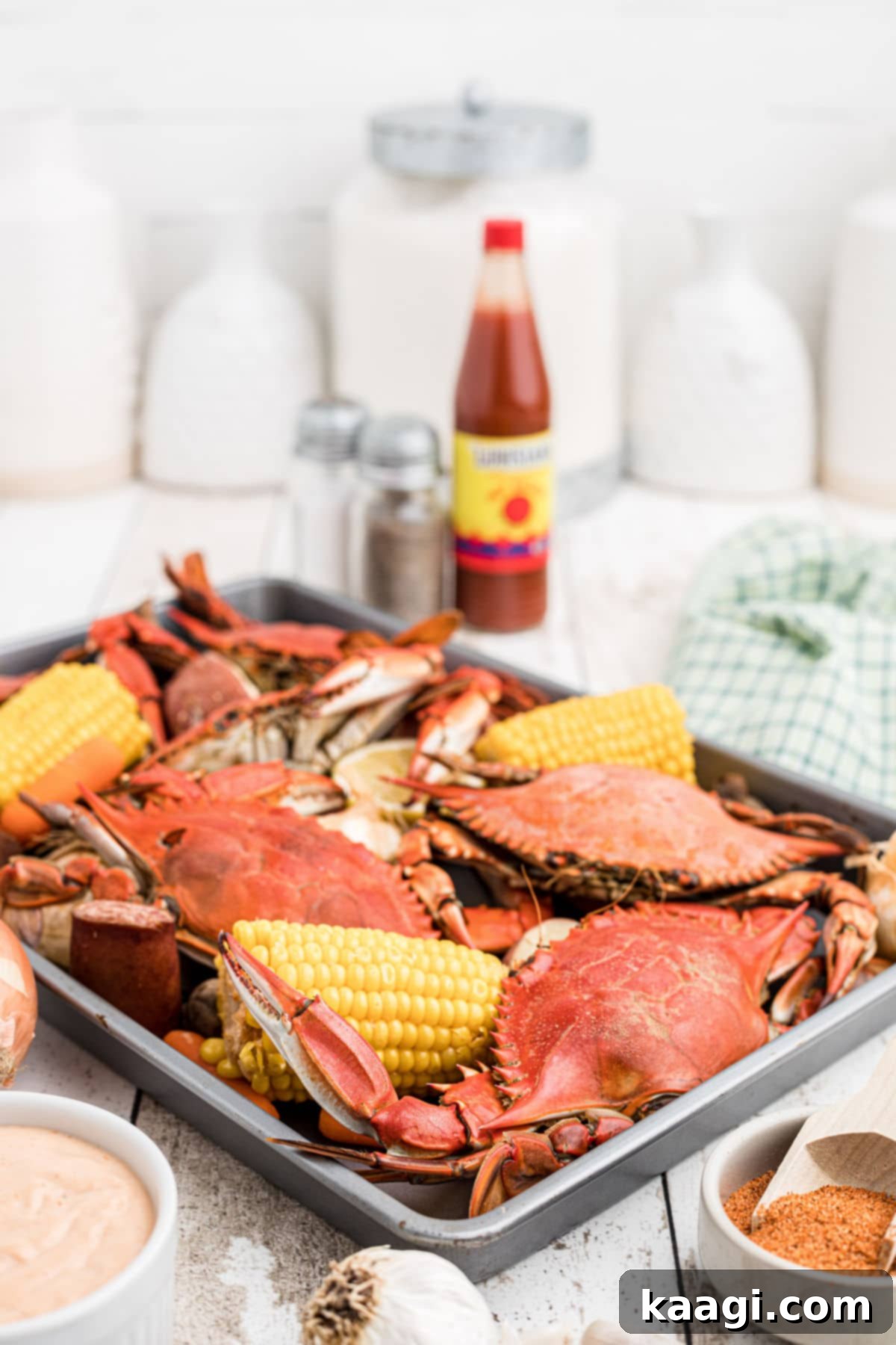 A tray full of Cajun crabs and veggies waiting to be eaten, showcasing a vibrant Louisiana Crab Boil.